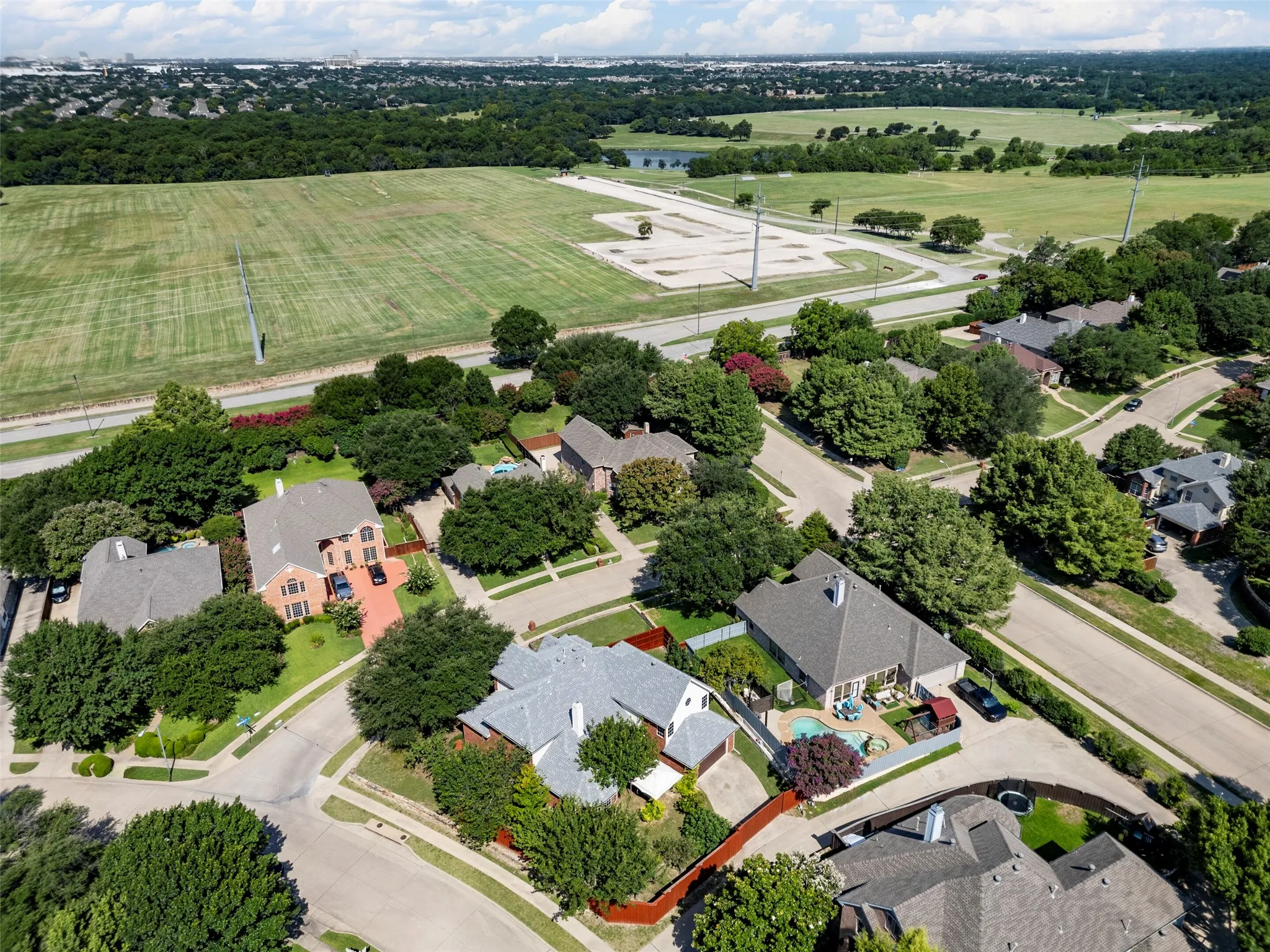 Expansive green space and wooded areas surrounding the residential properties