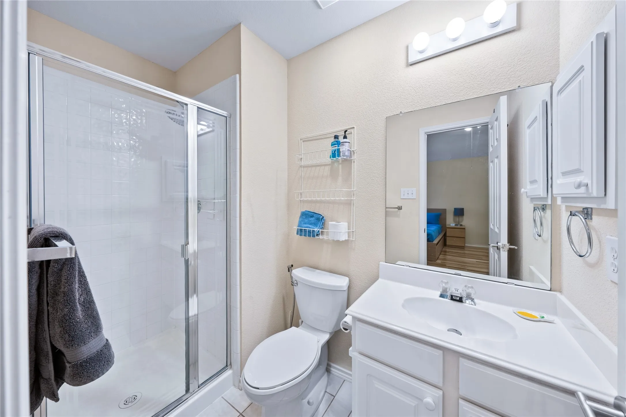 White vanity with integrated sink, chrome faucet, and a wall-mounted mirror