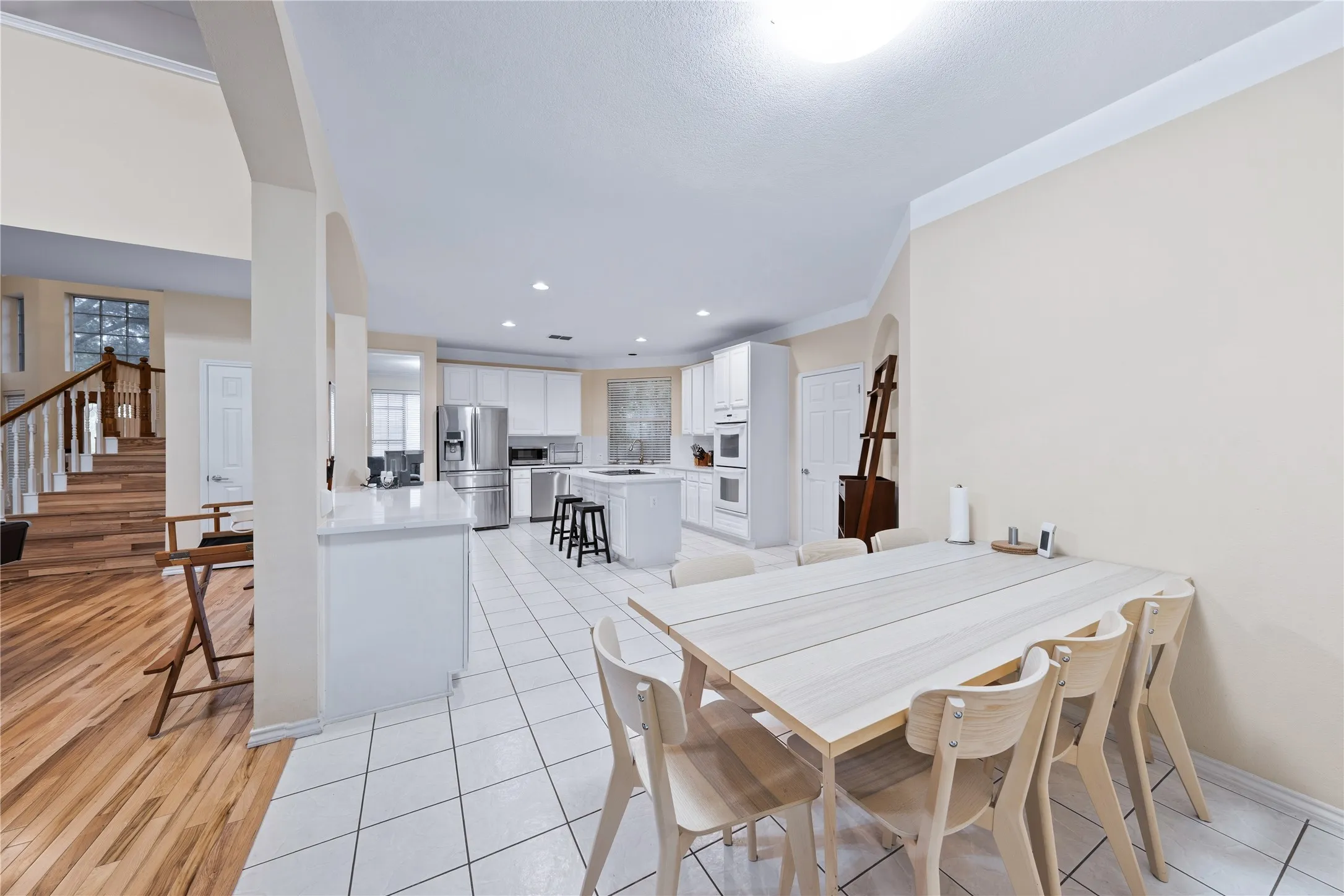 Open-concept kitchen with white cabinetry and stainless steel appliances