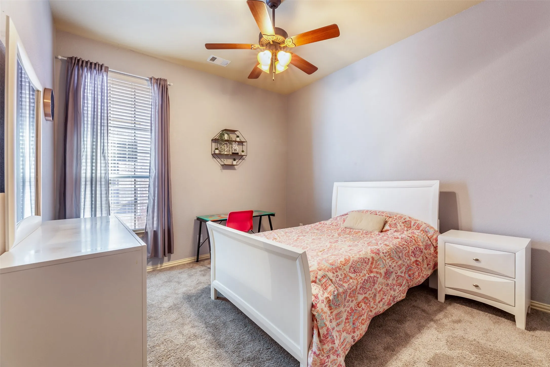 Bedroom with multiple windows, visible vents, and light colored carpet