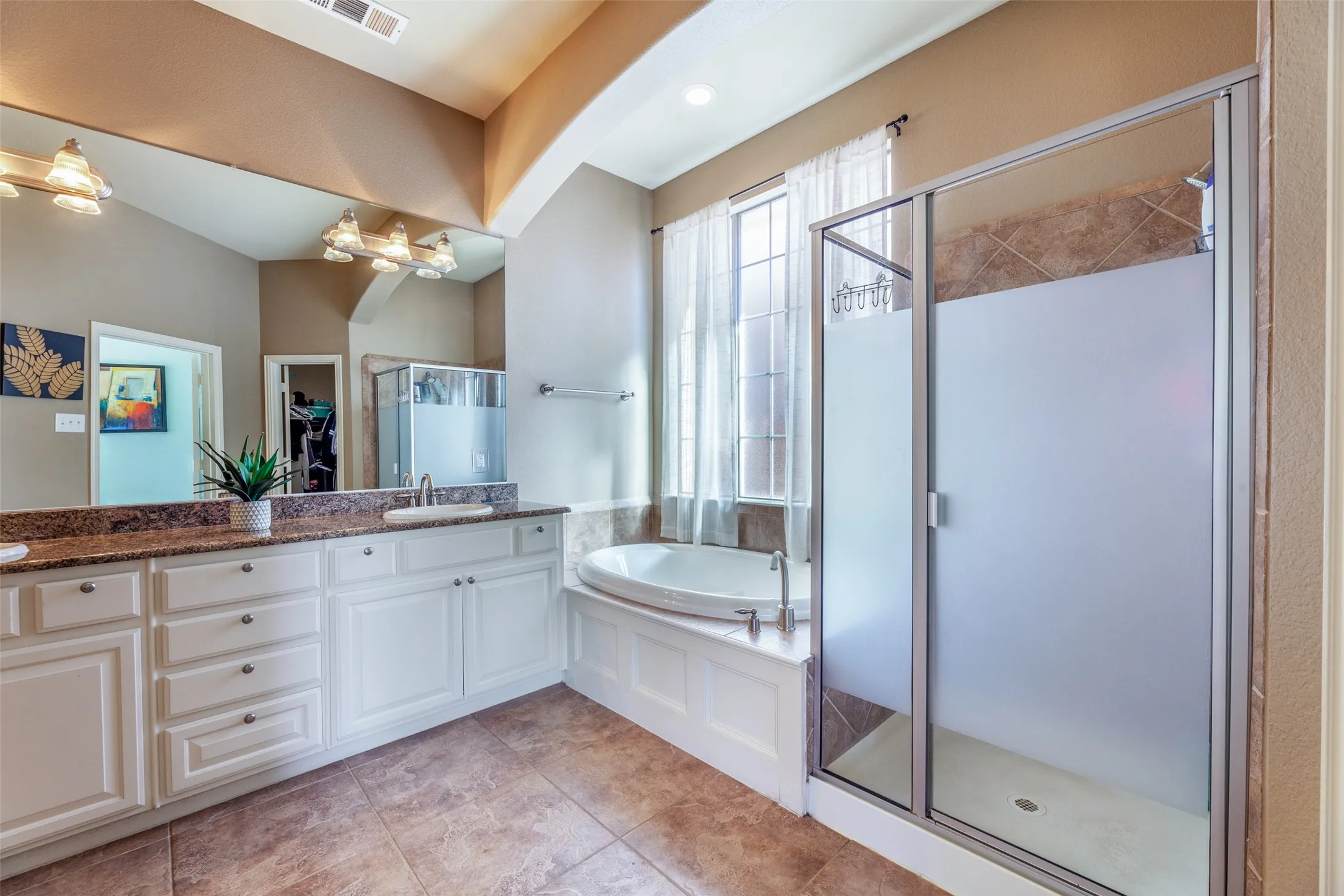 Bathroom with vanity, visible vents, tile patterned floors, a stall shower, and a garden tub
