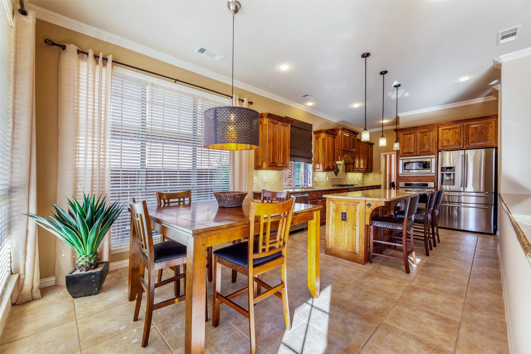 Dining area featuring ornamental molding, baseboards, light tile patterned floors, and visible vents