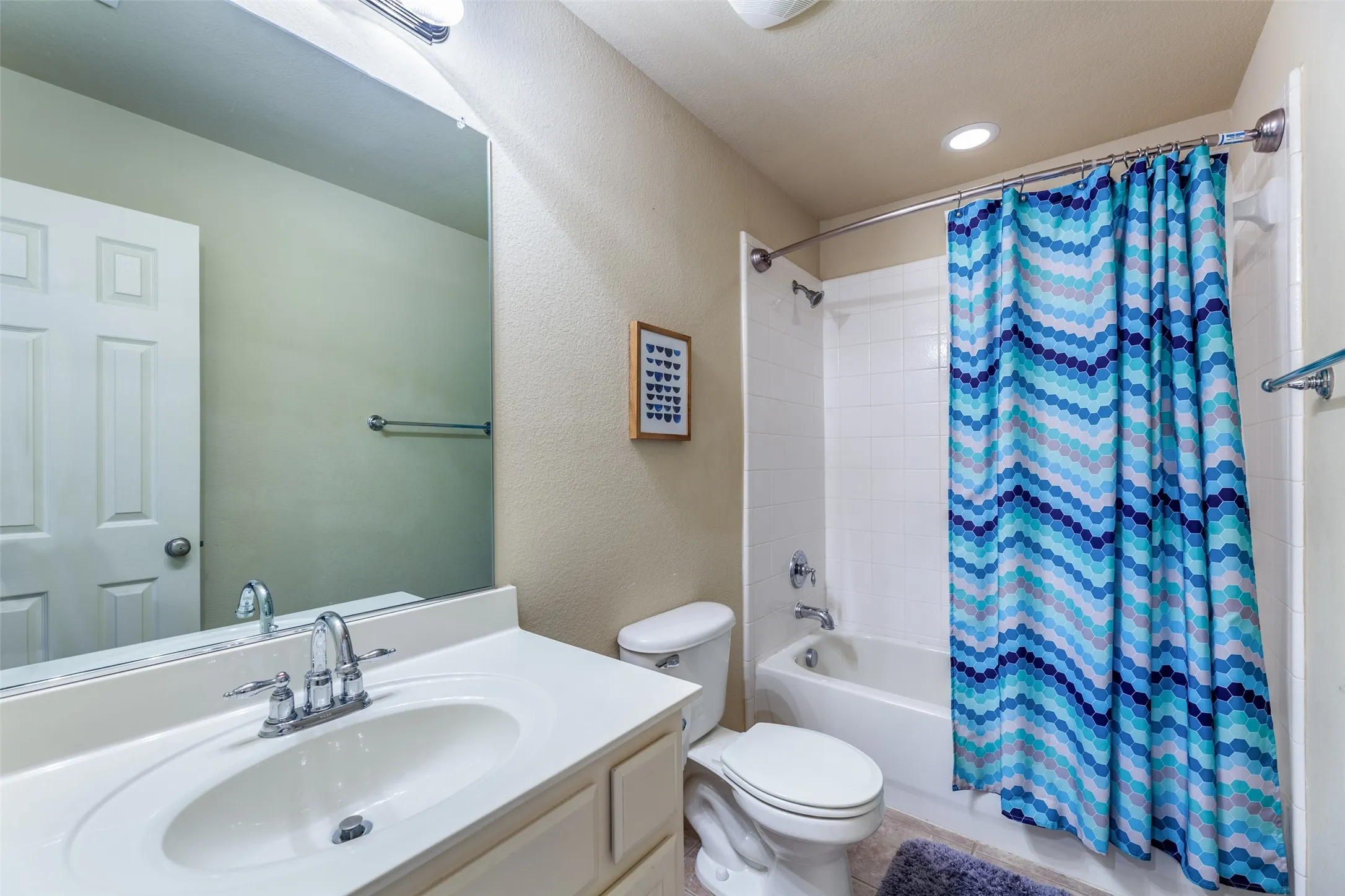 Full bath with shower / bath combo with shower curtain, toilet, and vanity