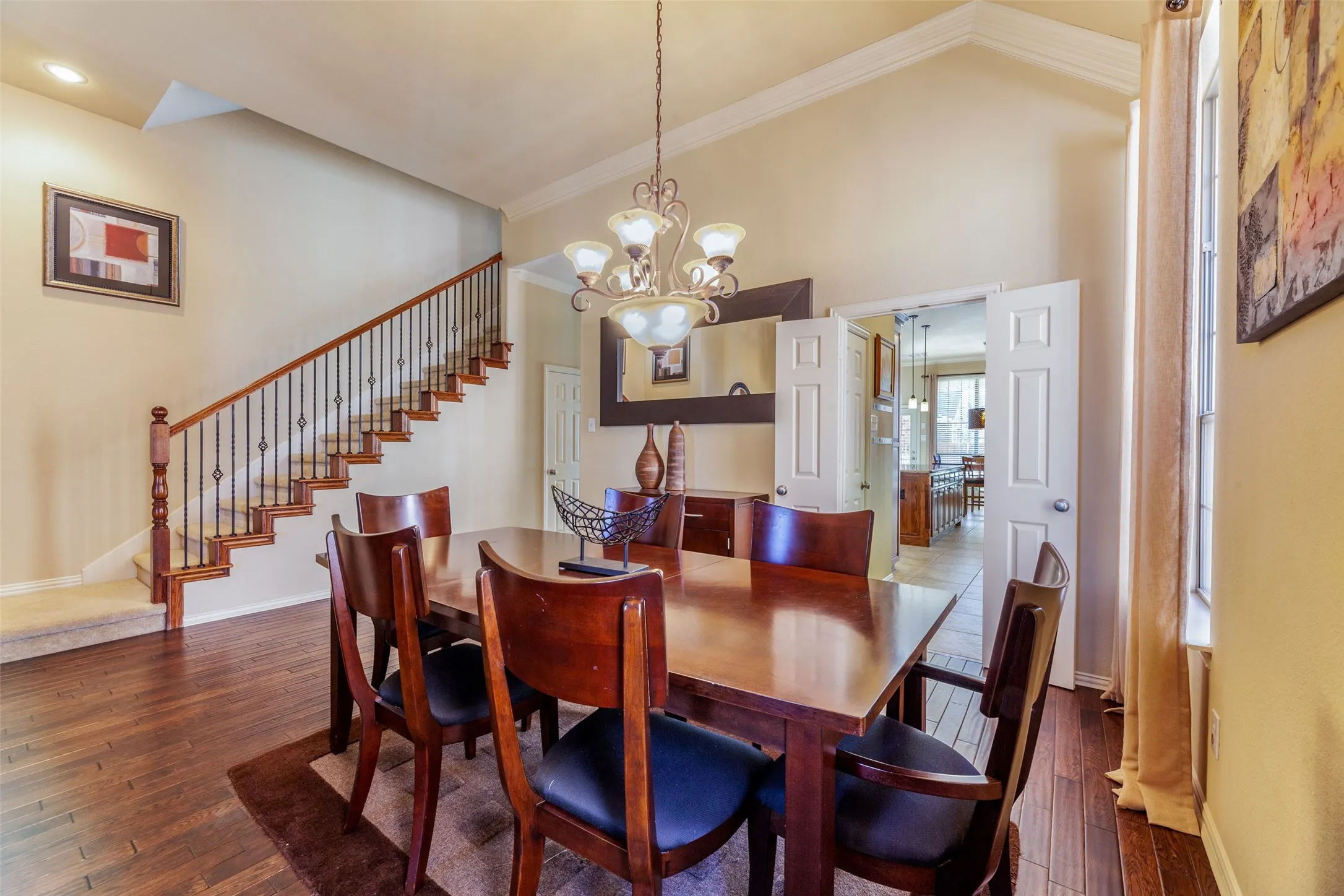 Dining space featuring baseboards, ornamental molding, an inviting chandelier, stairs, and dark wood-type flooring