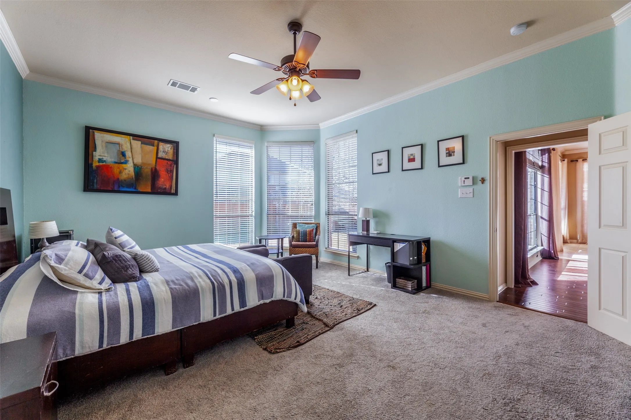 Bedroom with carpet flooring, ornamental molding, and visible vents