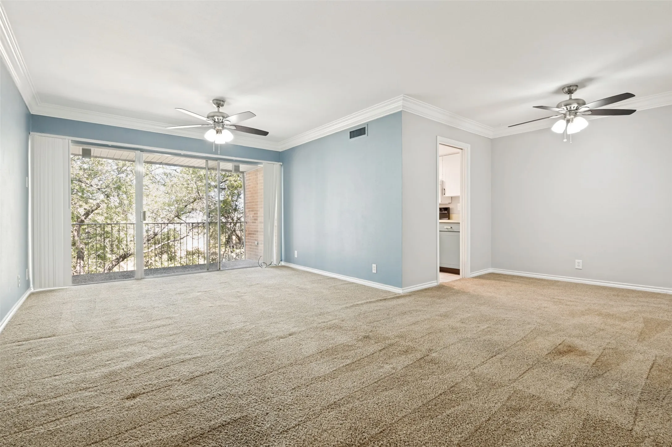 Spacious living room overlooking a tree filled walking path