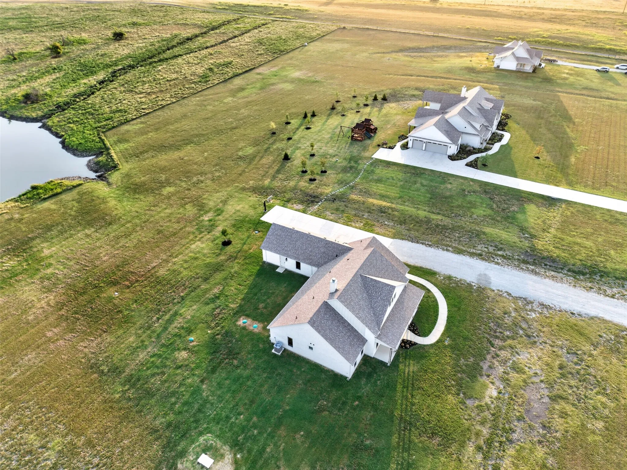Expansive green landscape with a prominent pond feature