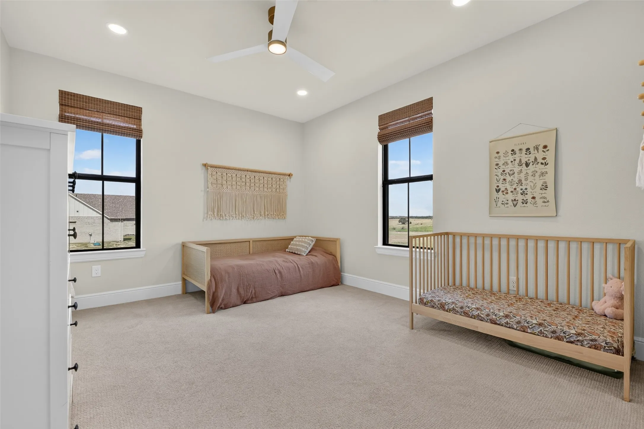 Carpeted room featuring two windows with woven shades, recessed lighting, and a ceiling fan