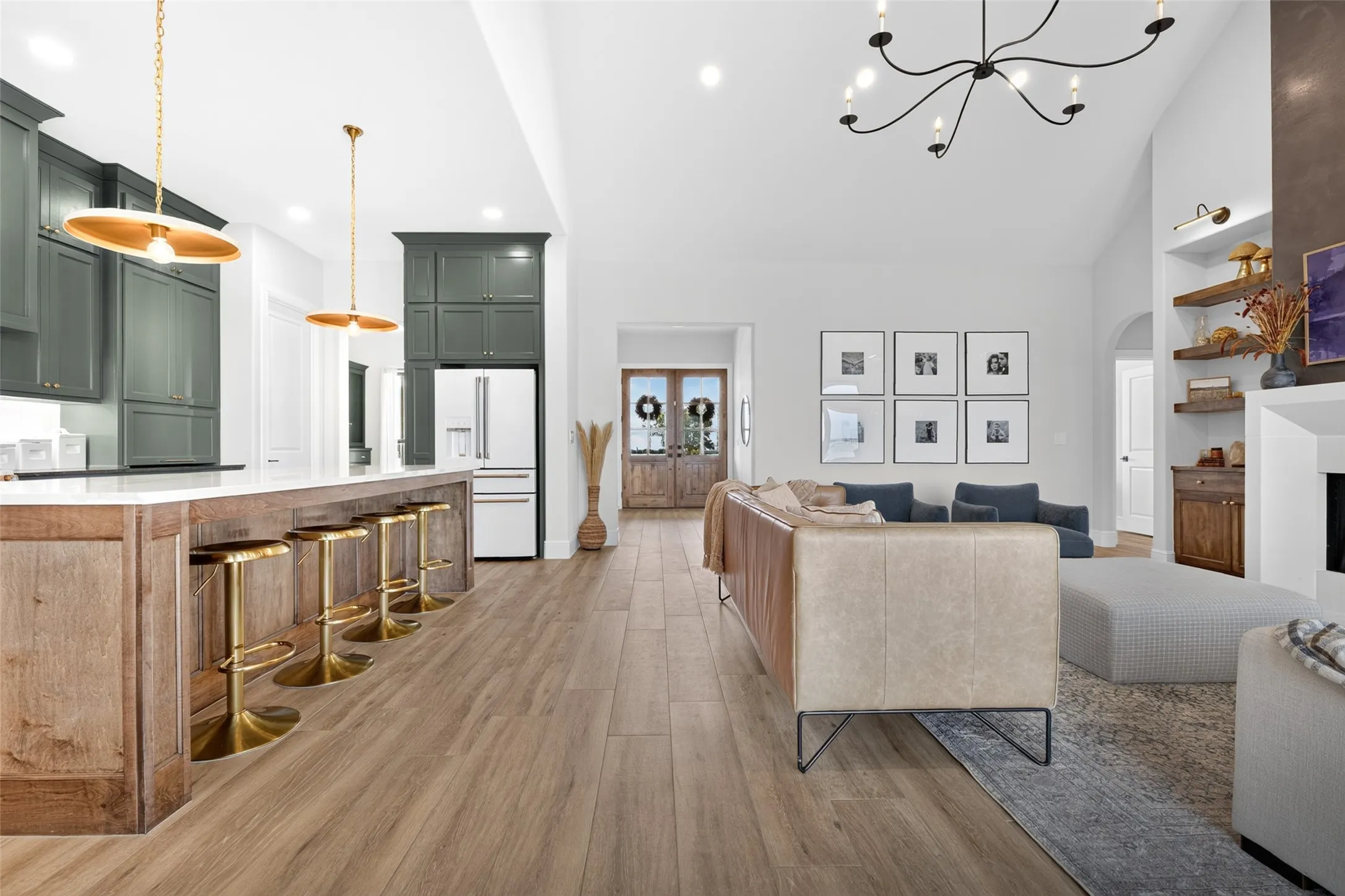 Vaulted ceiling, wood-finish flooring, kitchen island with seating, built-in shelving, and recessed lighting