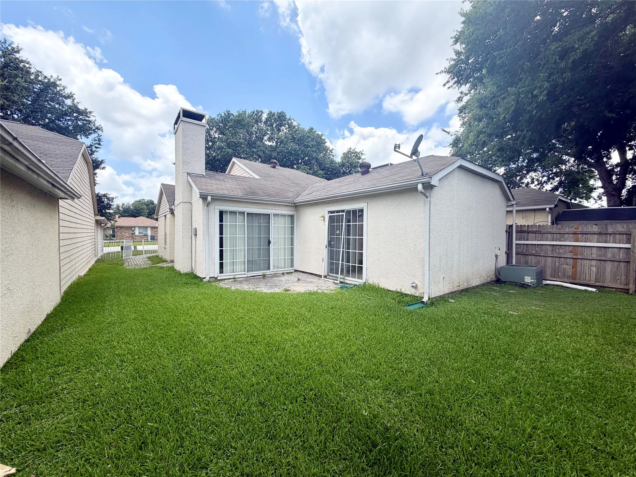 View of the backside of the home with 2 sliding doors to the yard.
