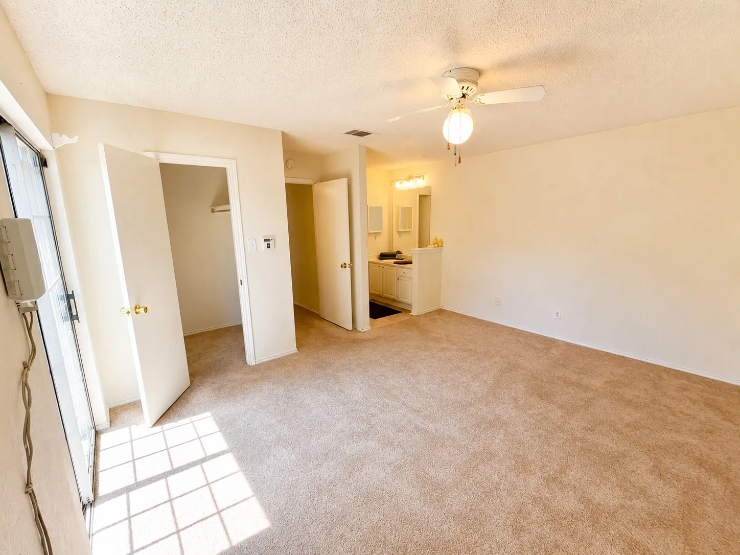Primary bedroom with private bathroom and vanity area and a walk in closet.