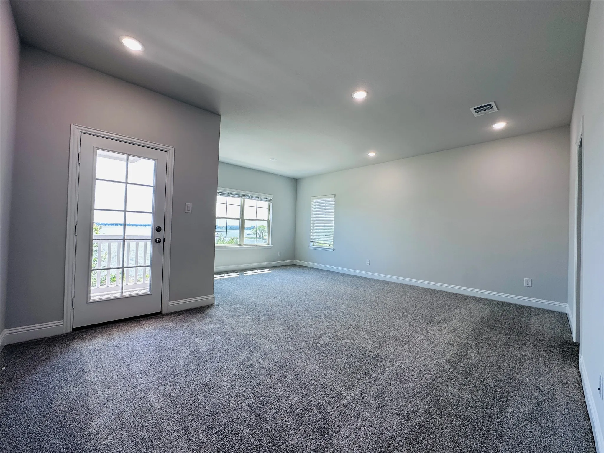 Spacious upper-level room featuring neutral wall finishes, recessed ceiling lighting, and plush carpeting throughout