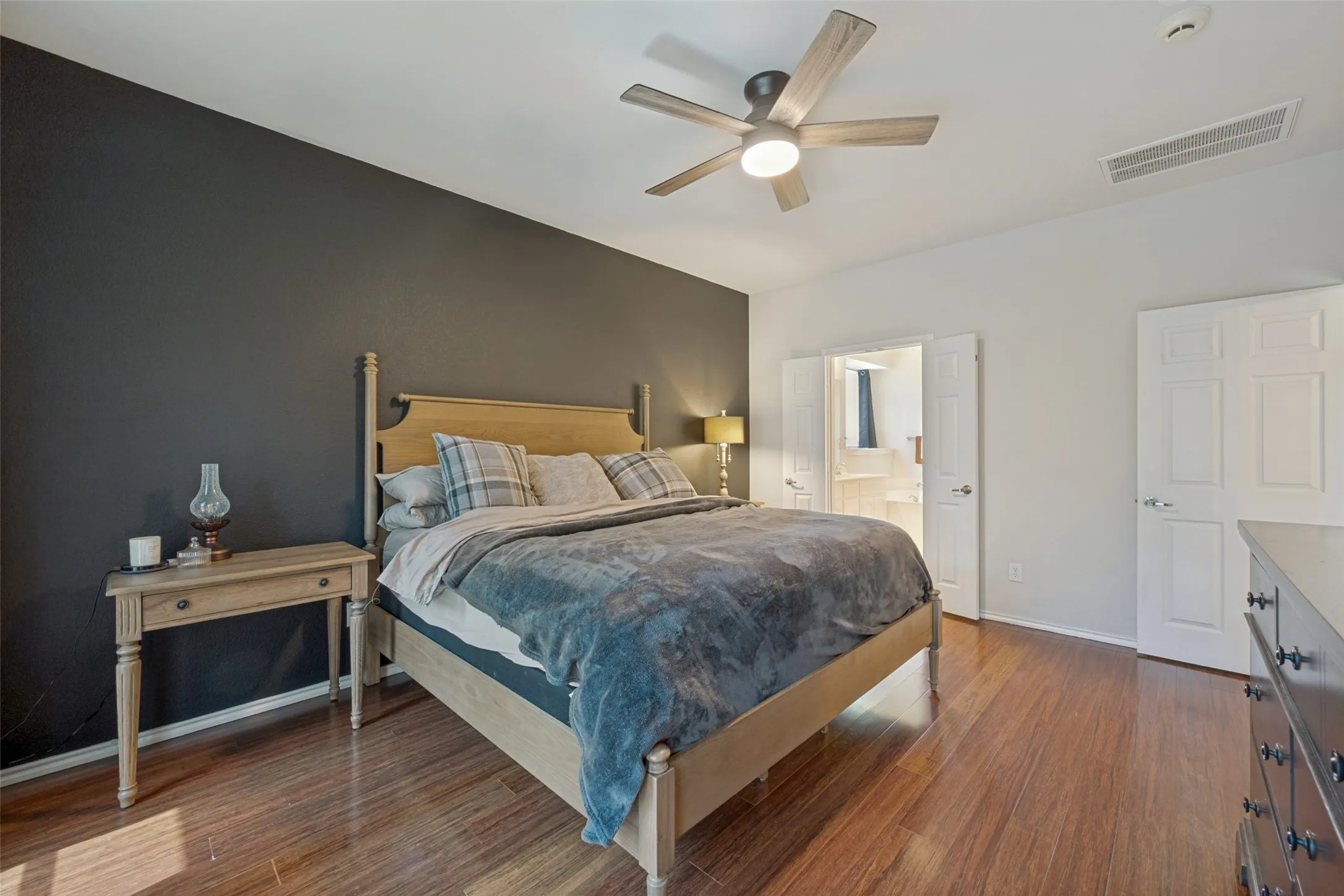 Wood-finish flooring with a ceiling fan and recessed lighting