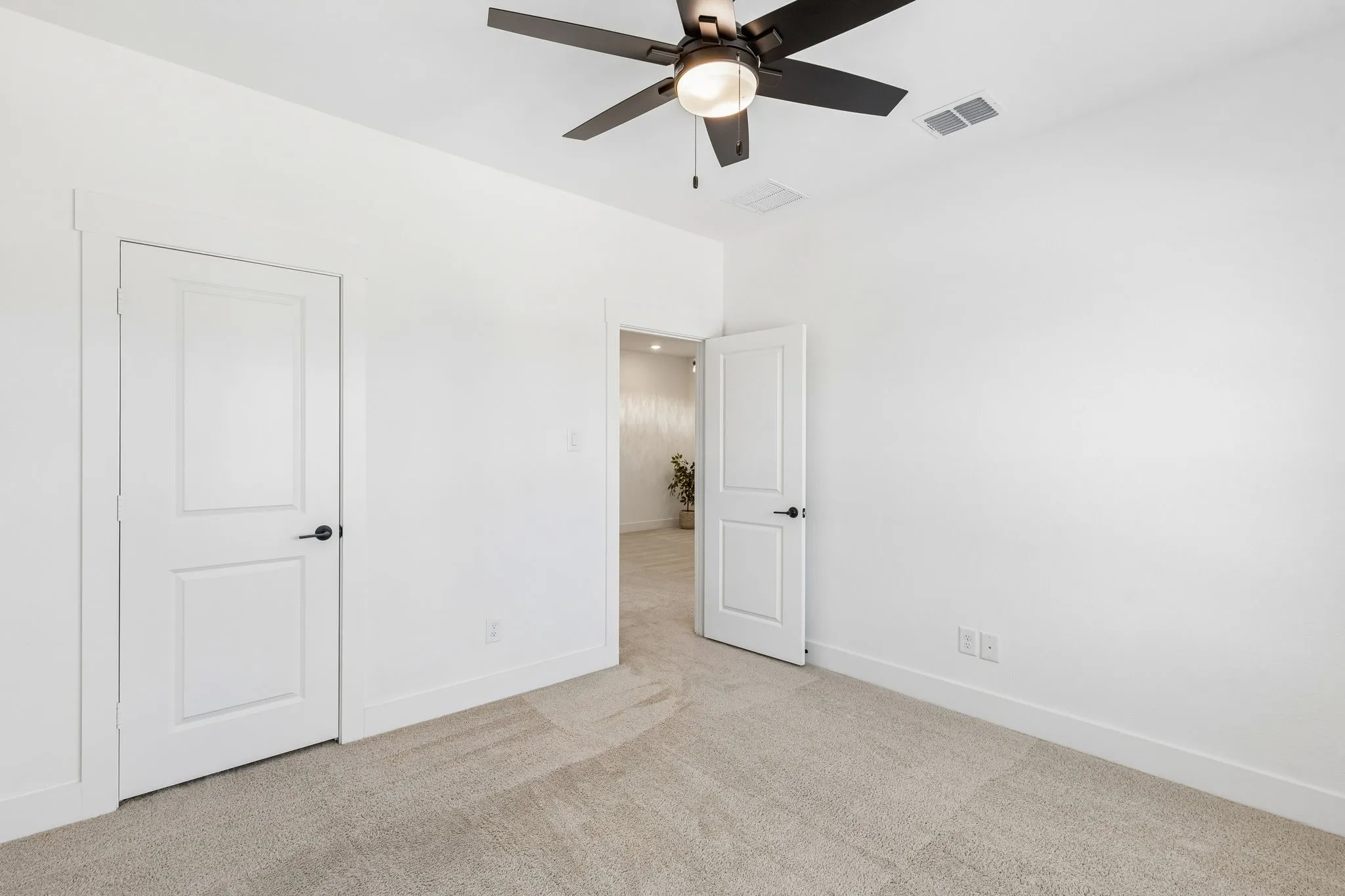 Neutral-toned carpet flooring and white walls