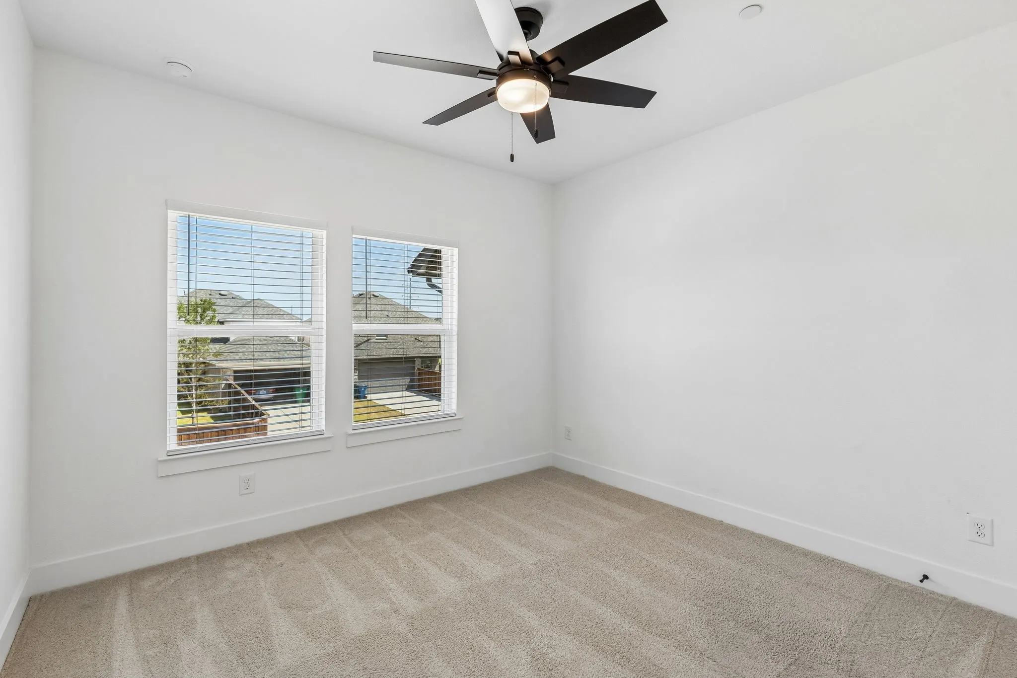Recessed lighting, ceiling fan with light fixture, dual windows with blinds, and neutral tone carpeting