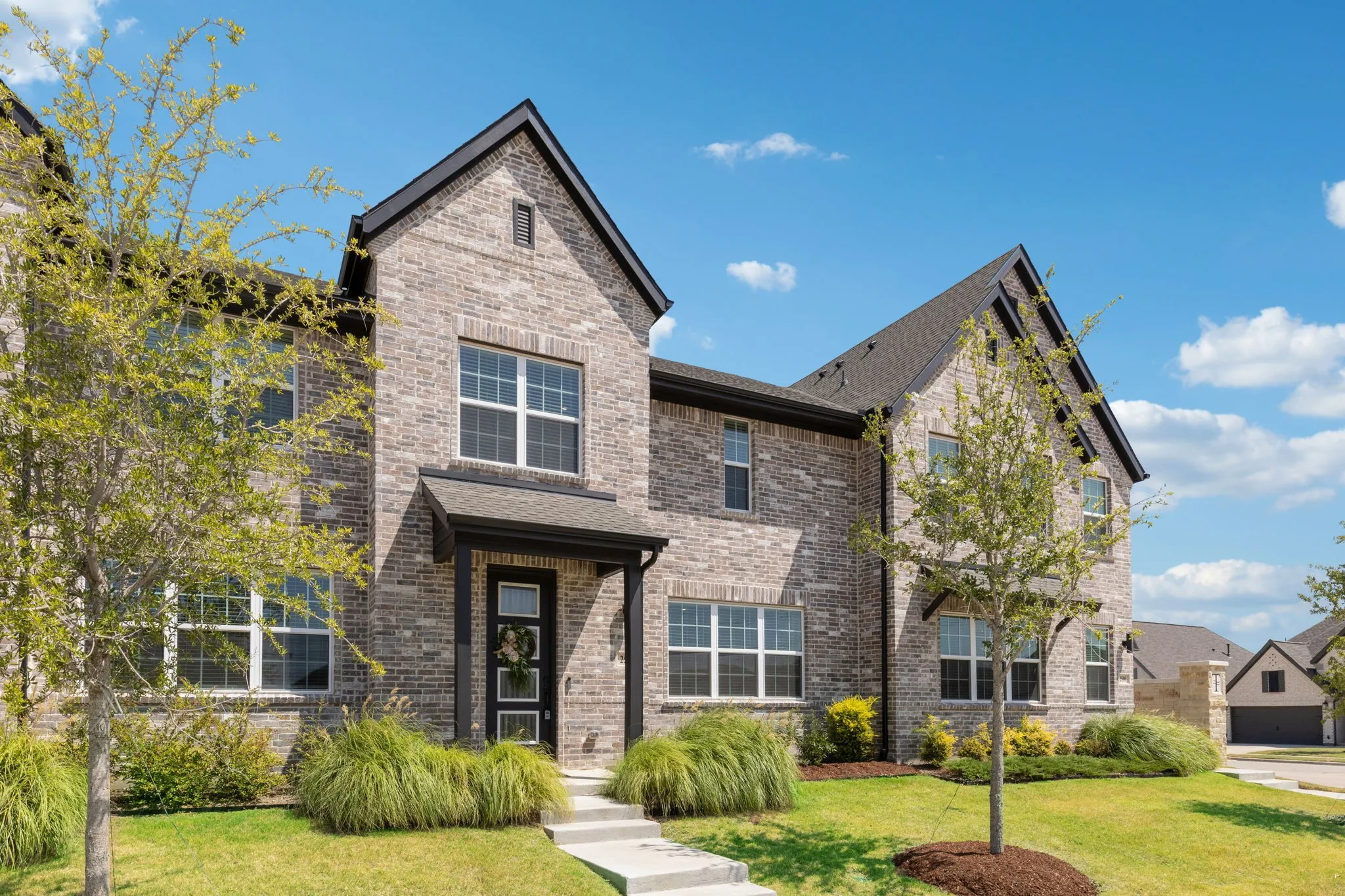 Brick exterior with dark trim accents, gabled rooflines, and a covered front entry