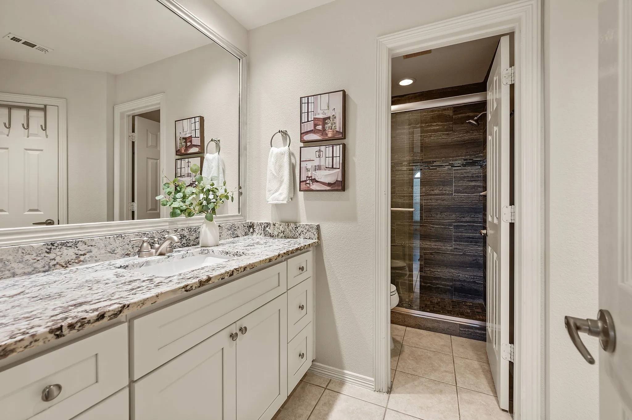 Bathroom featuring a vanity with a light-toned countertop, undermount sink, and shaker-style cabinetry