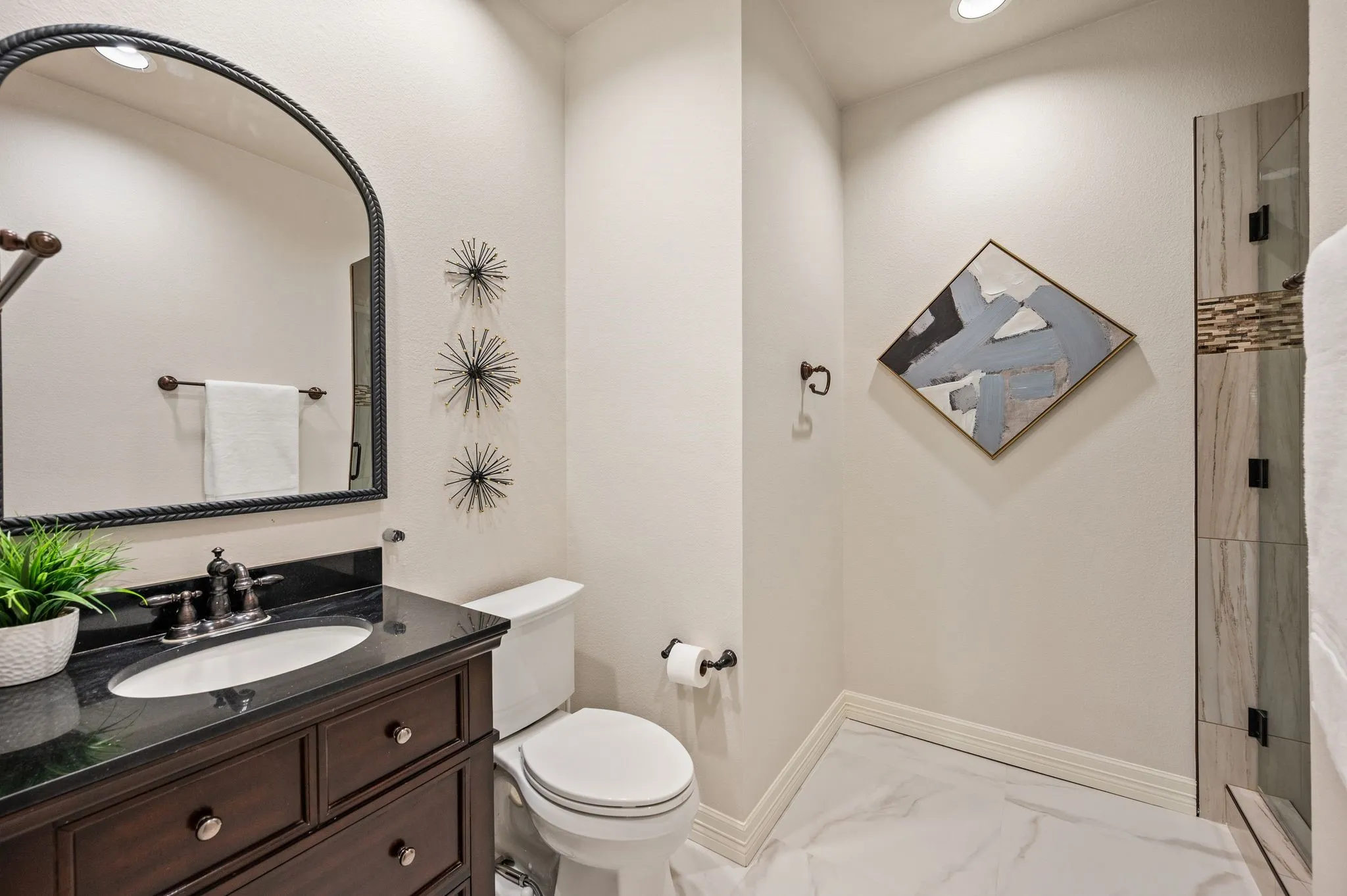 Dark wood-finish vanity with an undermount sink and dark countertop