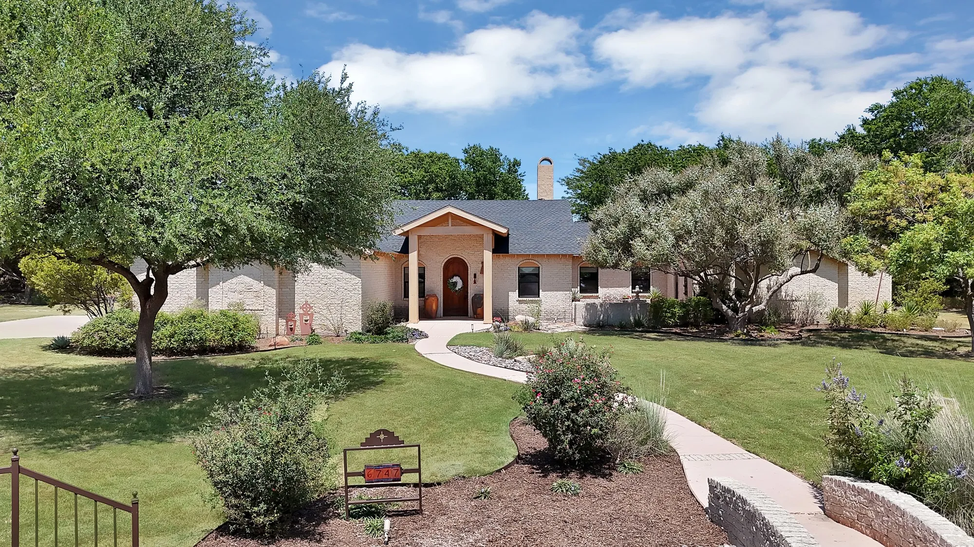 Front entrance facing south with southwestern style architecture and front courtyard.