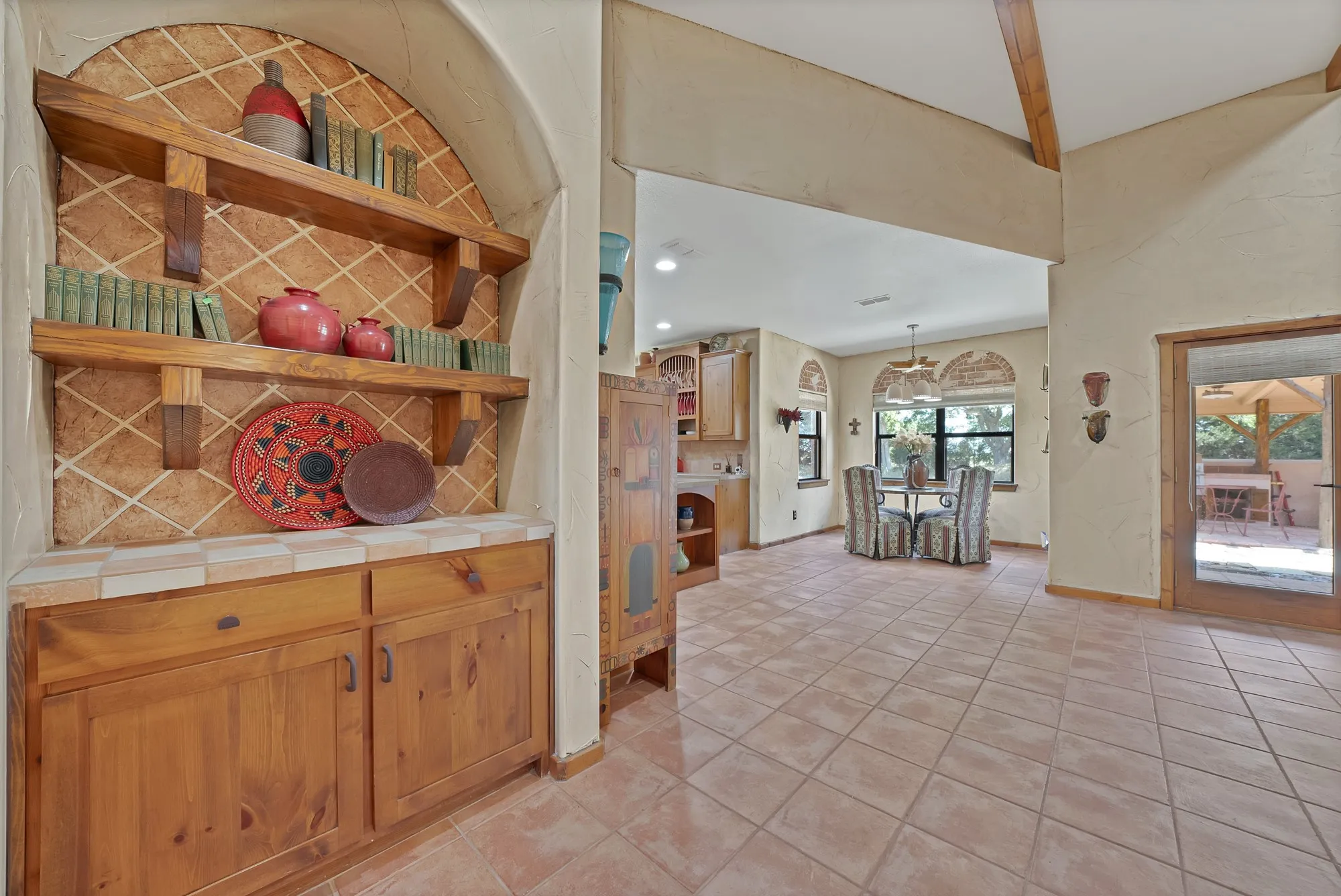 Butler's pantry with southwestern style built-in cabinetry and hardware looking towards the kitchen and breakfast nook.