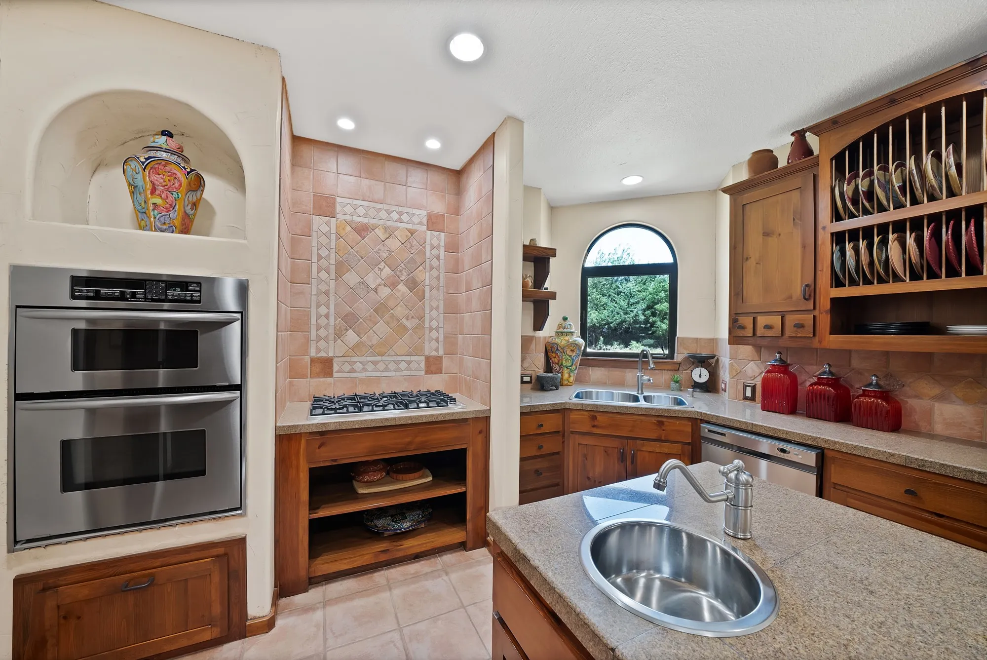 Kitchen continues the southwestern architecture with the art niches, wood-shelving and SS appliances, 6-burner cooktop and additional sink in the island.