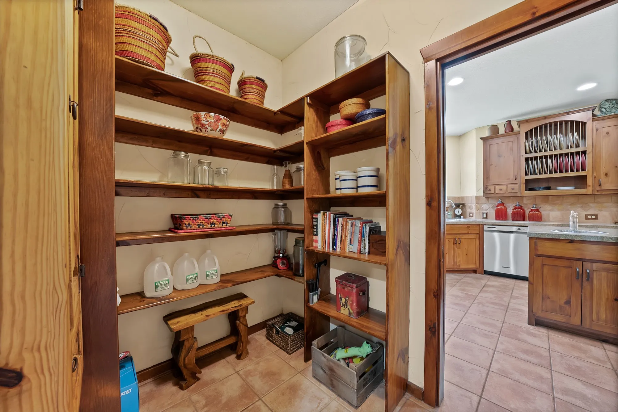 Large walk-in pantry with plenty of wood shelving.