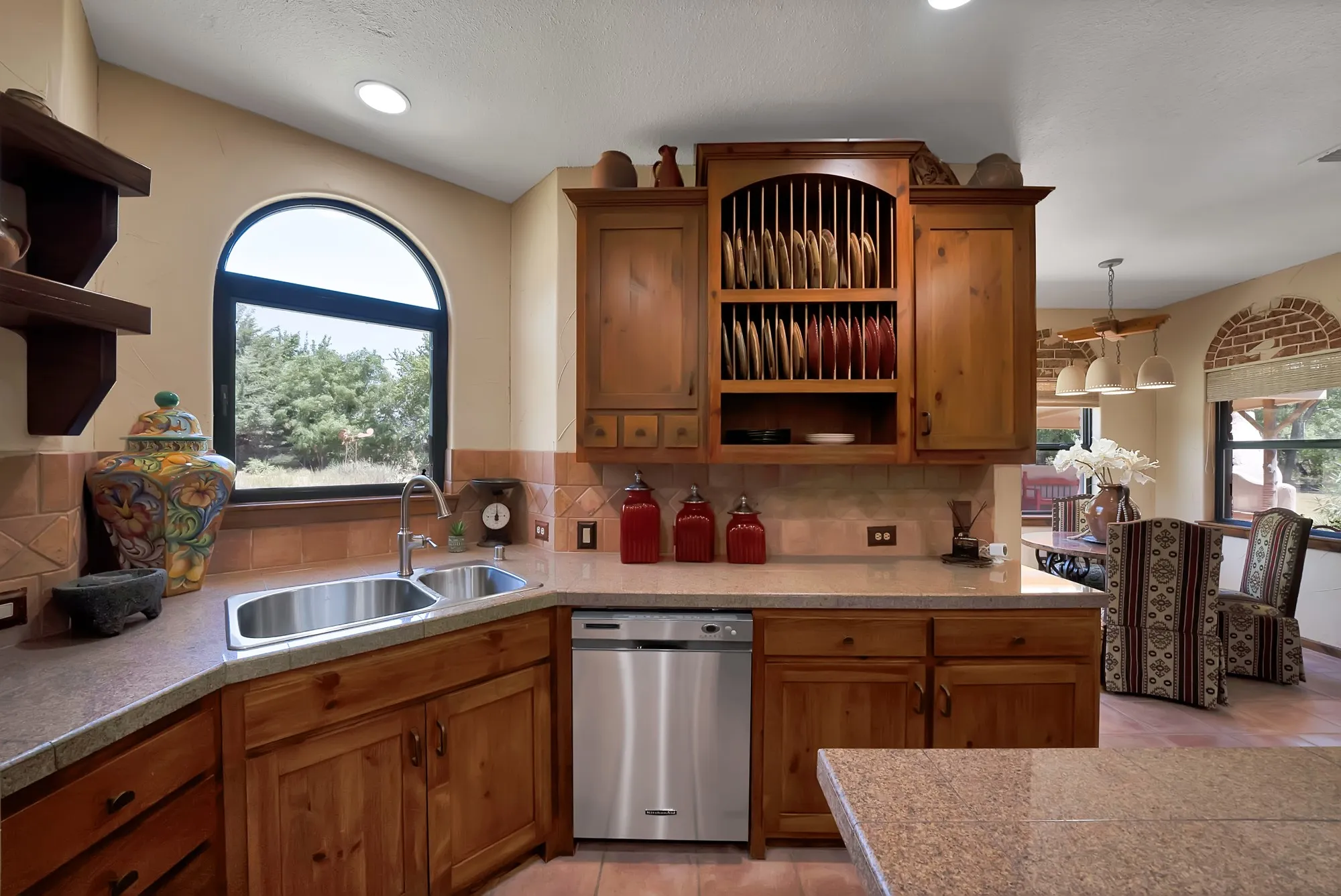 Kitchen with wood built-ins to highlight stoneware with a large window over kitchen sink looking towards the  large backyard.