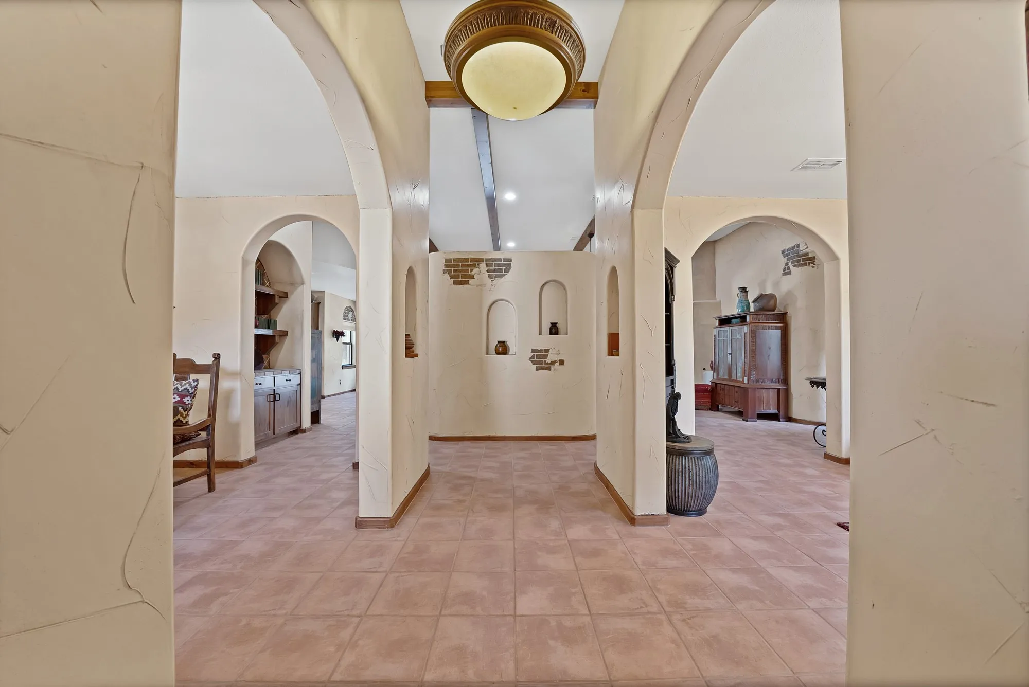 Foyer flanked by beautiful southwest style archway entries looking towards the dining on the left and living on the right.
