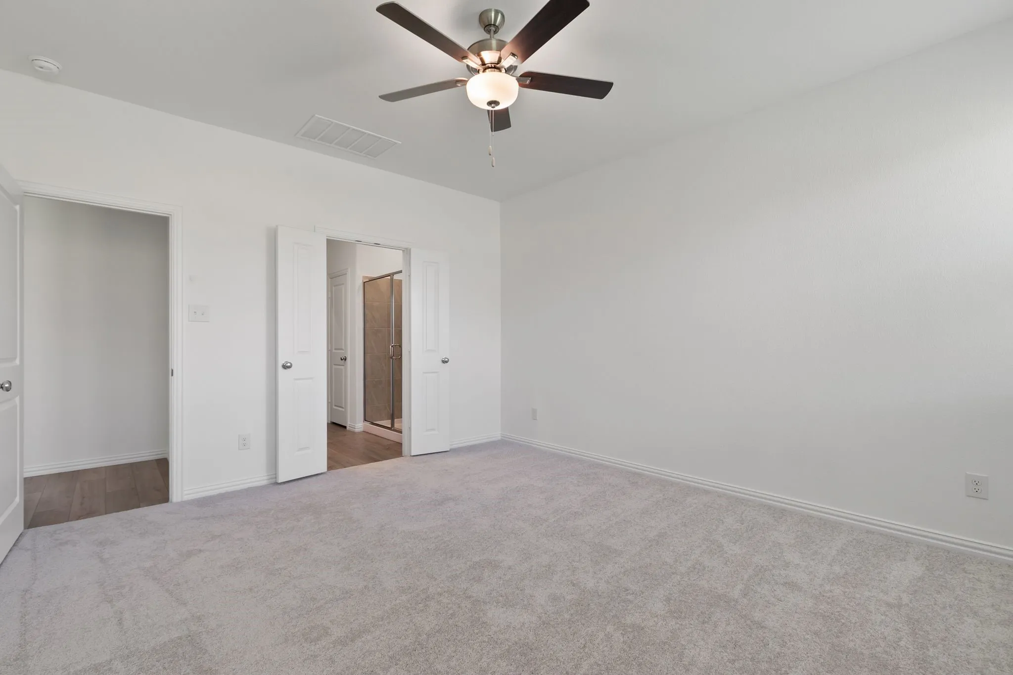 Unfurnished bedroom with ceiling fan and dark colored carpet