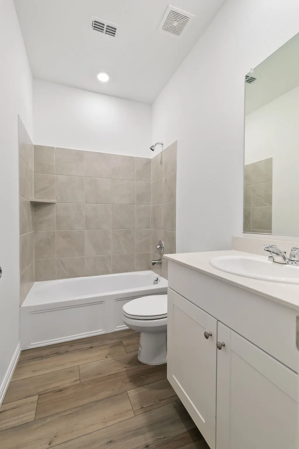 Full bathroom with tiled shower / bath, toilet, and vanity with extensive cabinet space