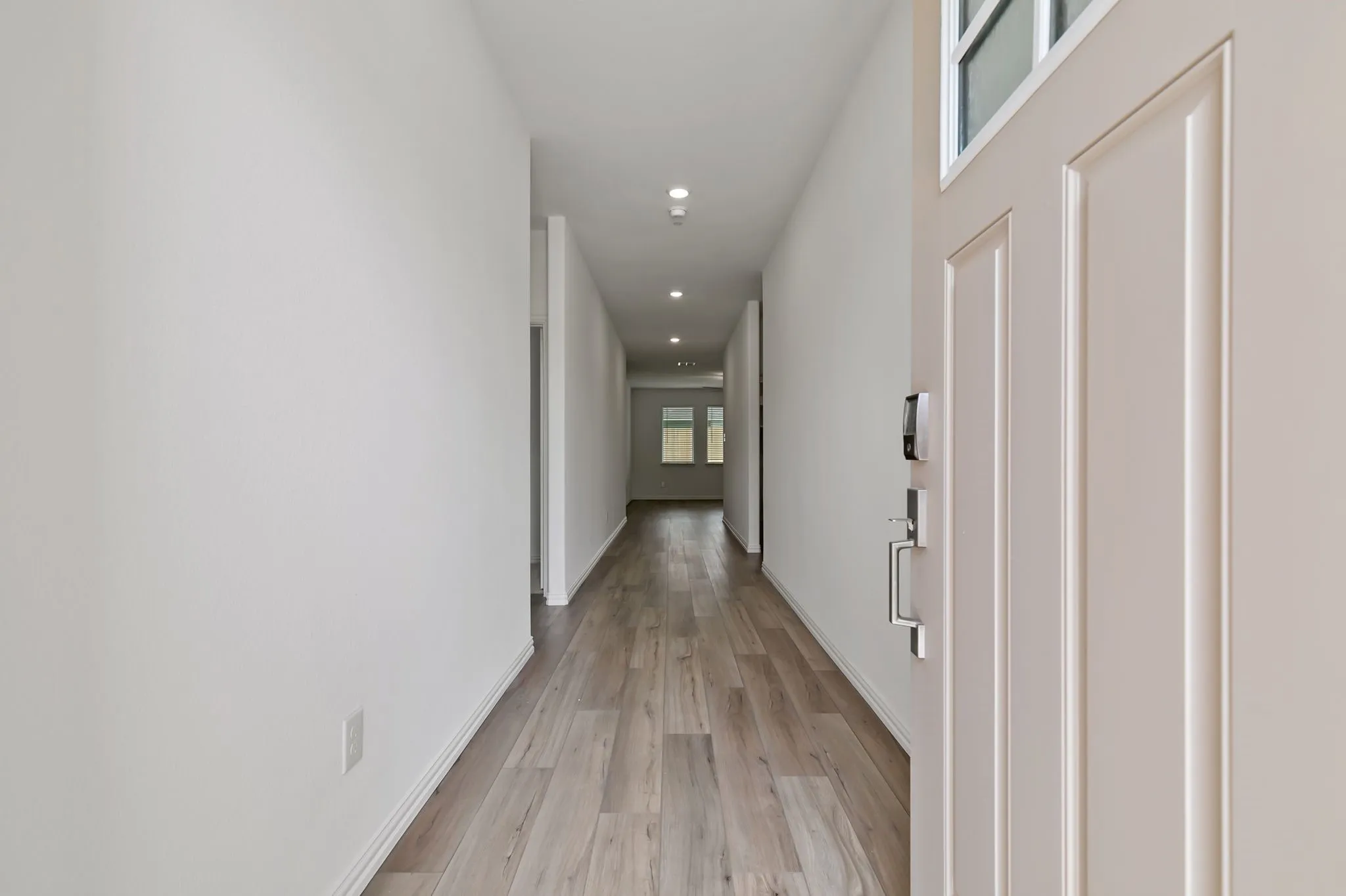 Corridor with light hardwood / wood-style flooring