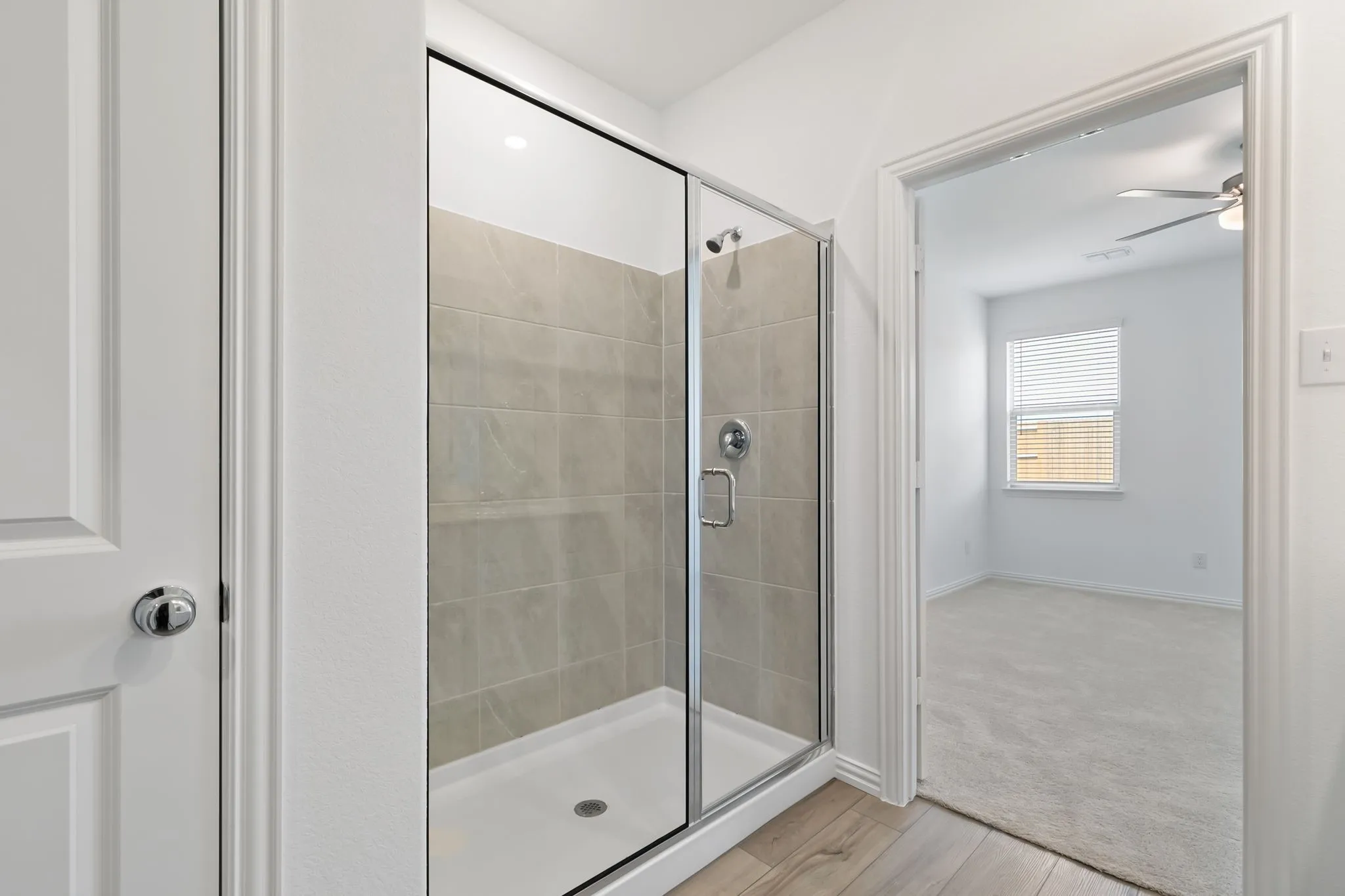 Bathroom featuring walk in shower, wood-type flooring, and ceiling fan