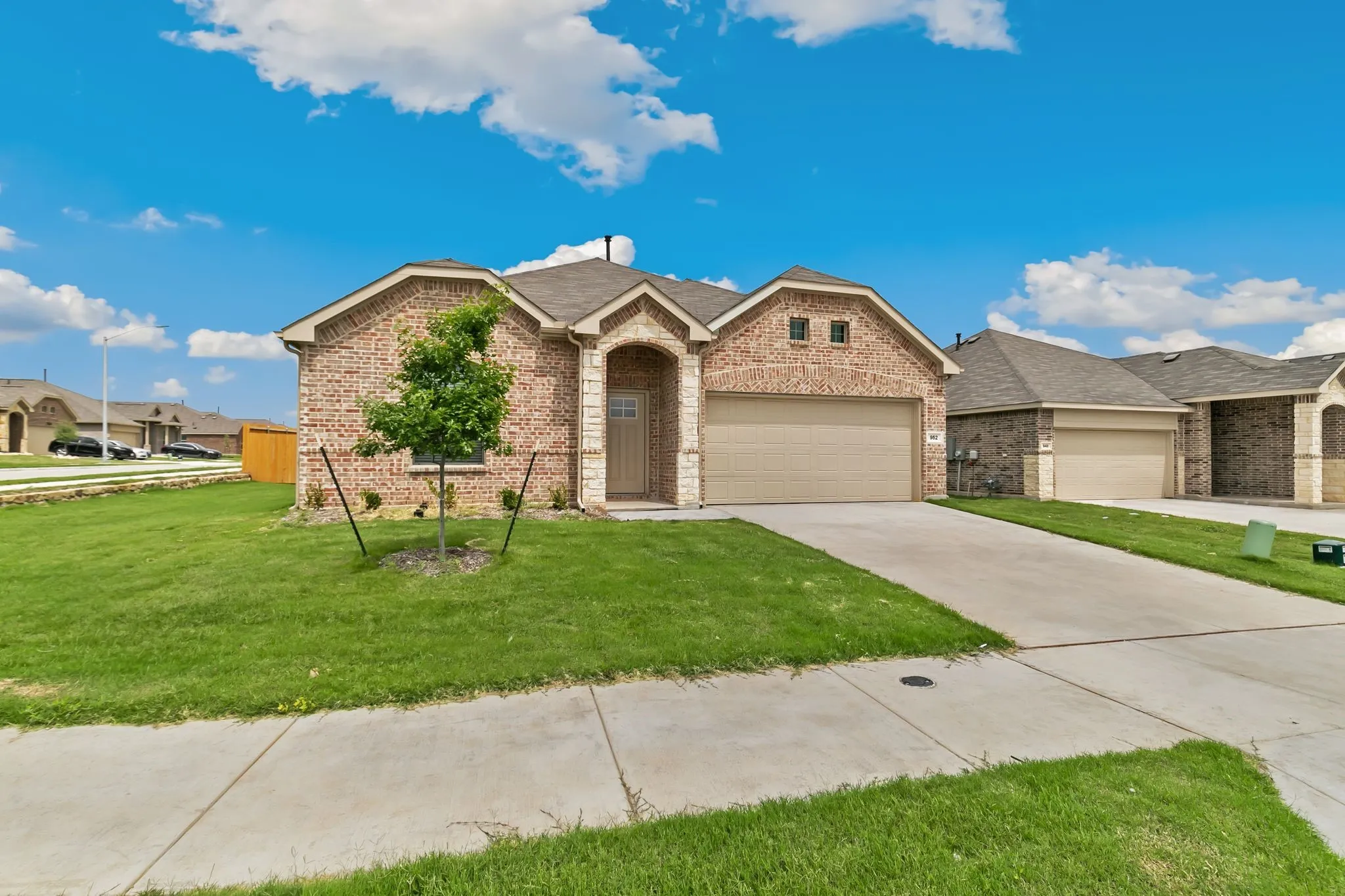 View of front of property with a garage and a front lawn