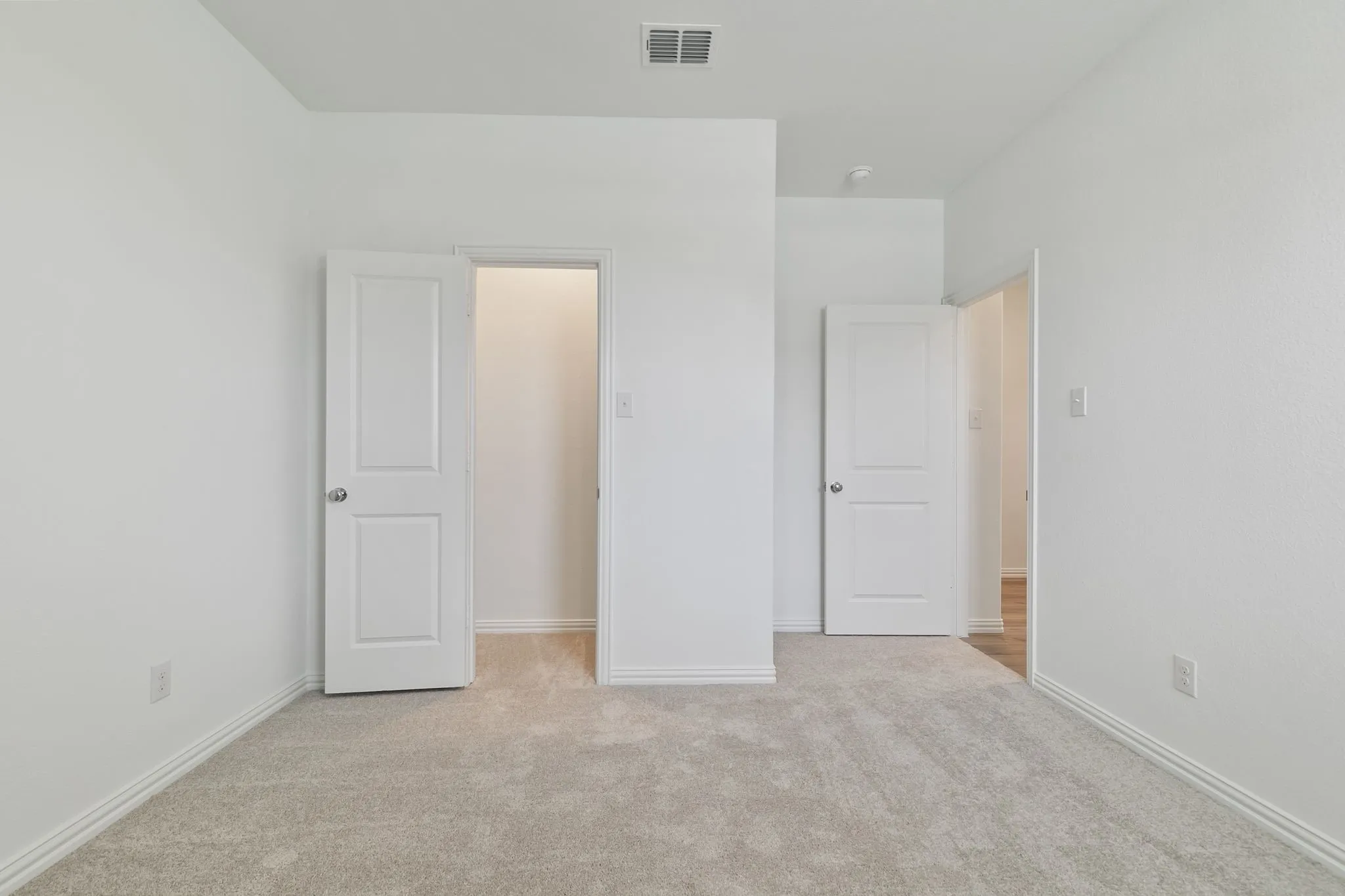 Unfurnished bedroom featuring light colored carpet