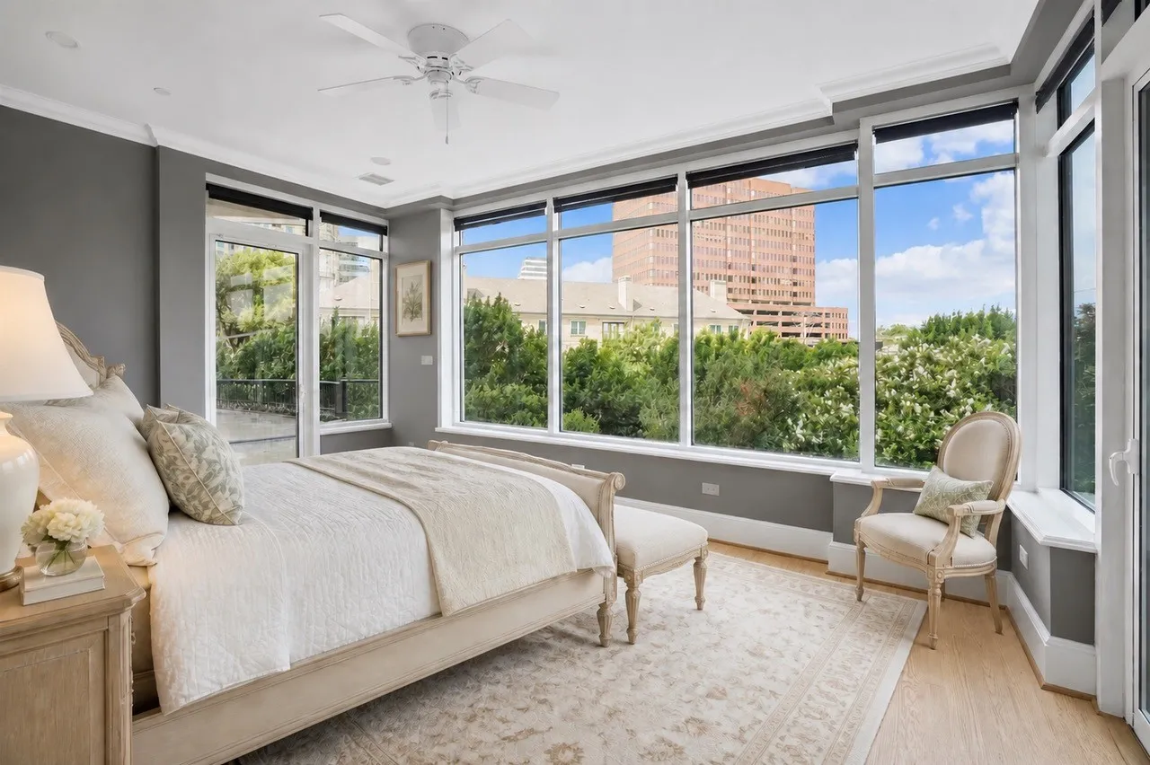 Inviting and private Owner's Suite with bank of windows viewing the skyline of Dallas and surrounding cityscape plus sitting area,  two bathrooms and two walk-in custom closets. Virtual staging