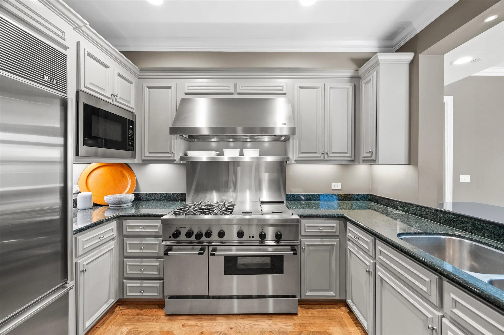 The chef's kitchen is the heart of this home offering a Thermador professional oven with gas burners and two grills, Bosch dishwasher, built-in microwave and Sub-Zero refrigerator. This custom kitchen with pull-out shelving is open to the living area for ease in everyday living and entertaining.
