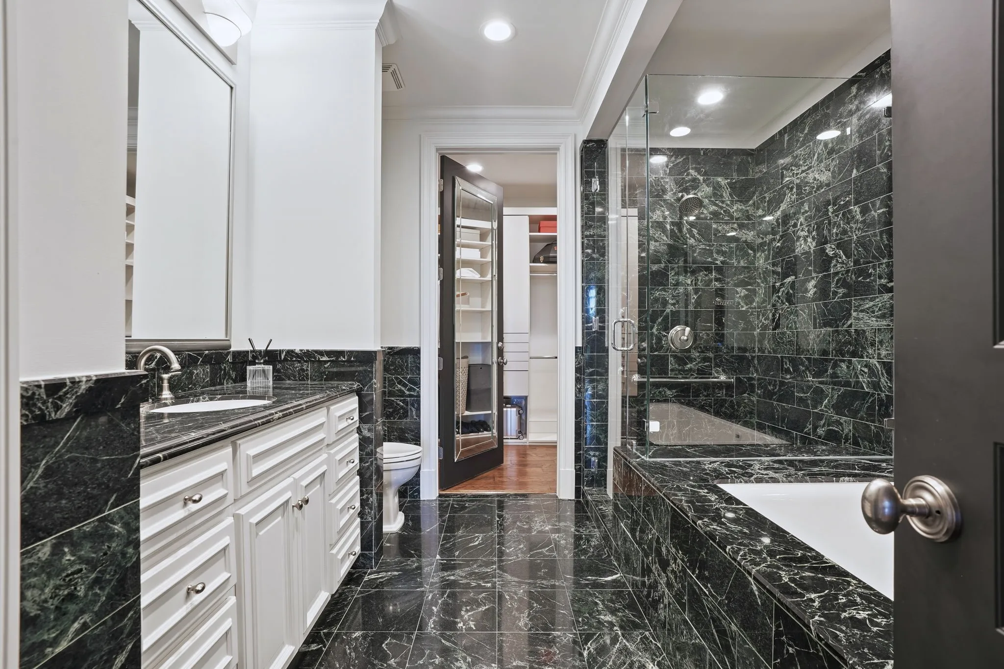 Large primary bathroom with separate shower and tub, and spacious walk-in closet.