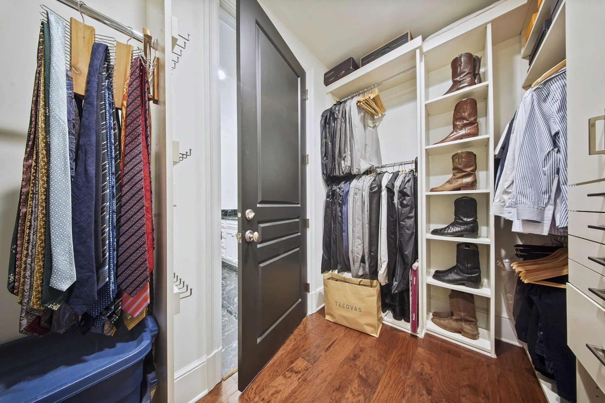 Another view of the large walk-in closet featuring custom built-in cabinetry.