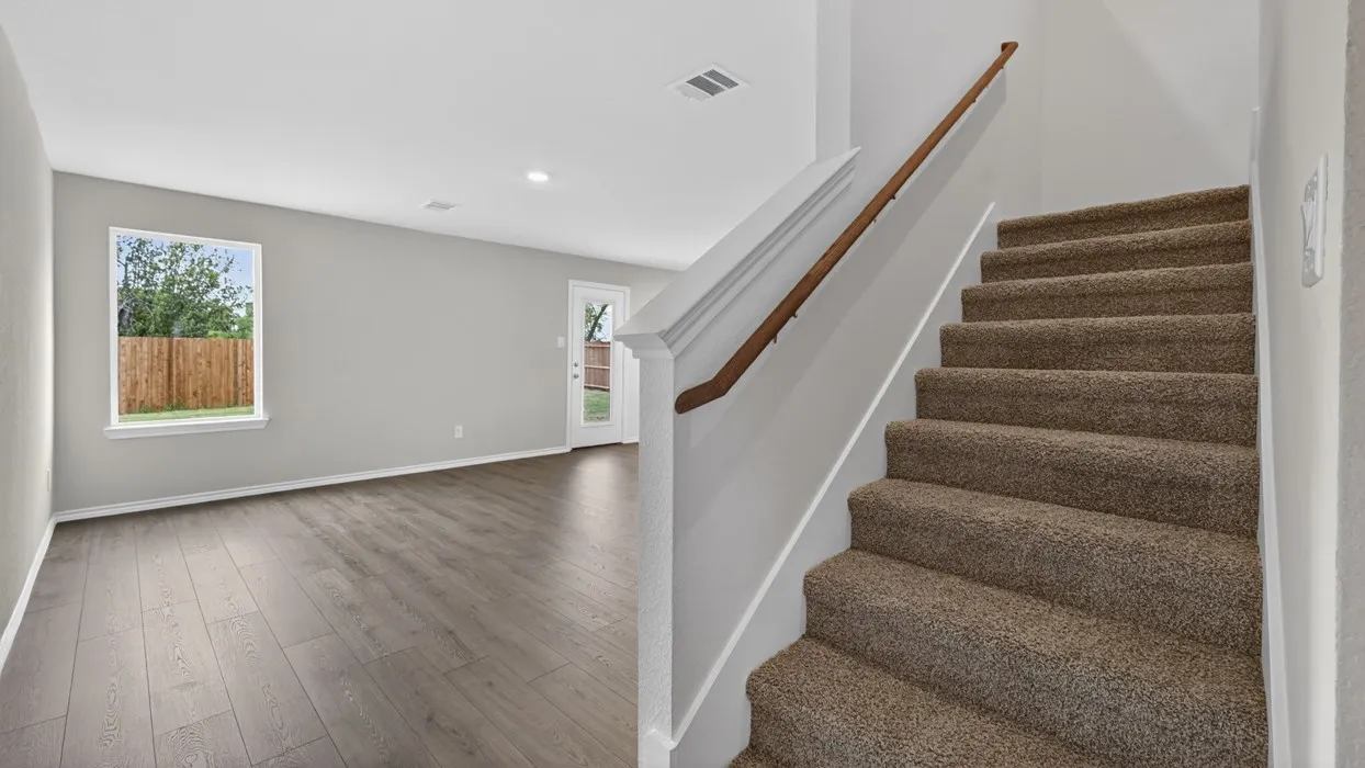 Open-concept living space featuring wood-finish flooring, recessed lighting, and direct patio access