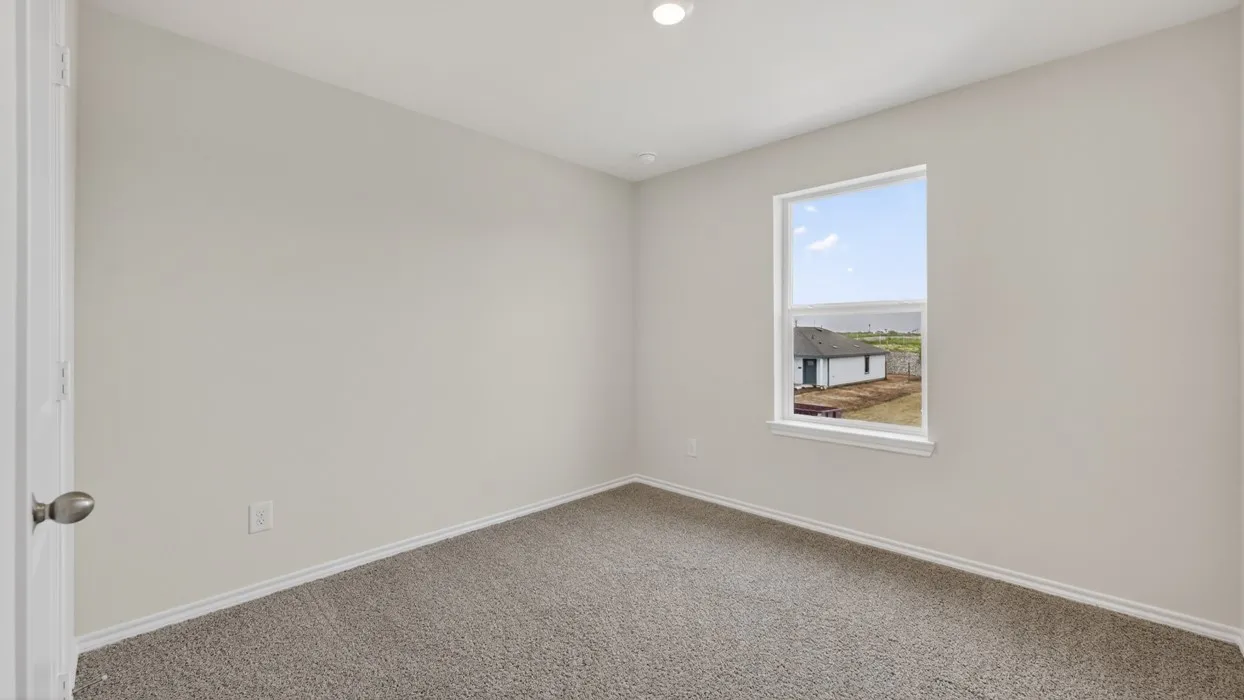 Neutral tone wall color, recessed ceiling lighting, light gray carpet, and a single window with white trim