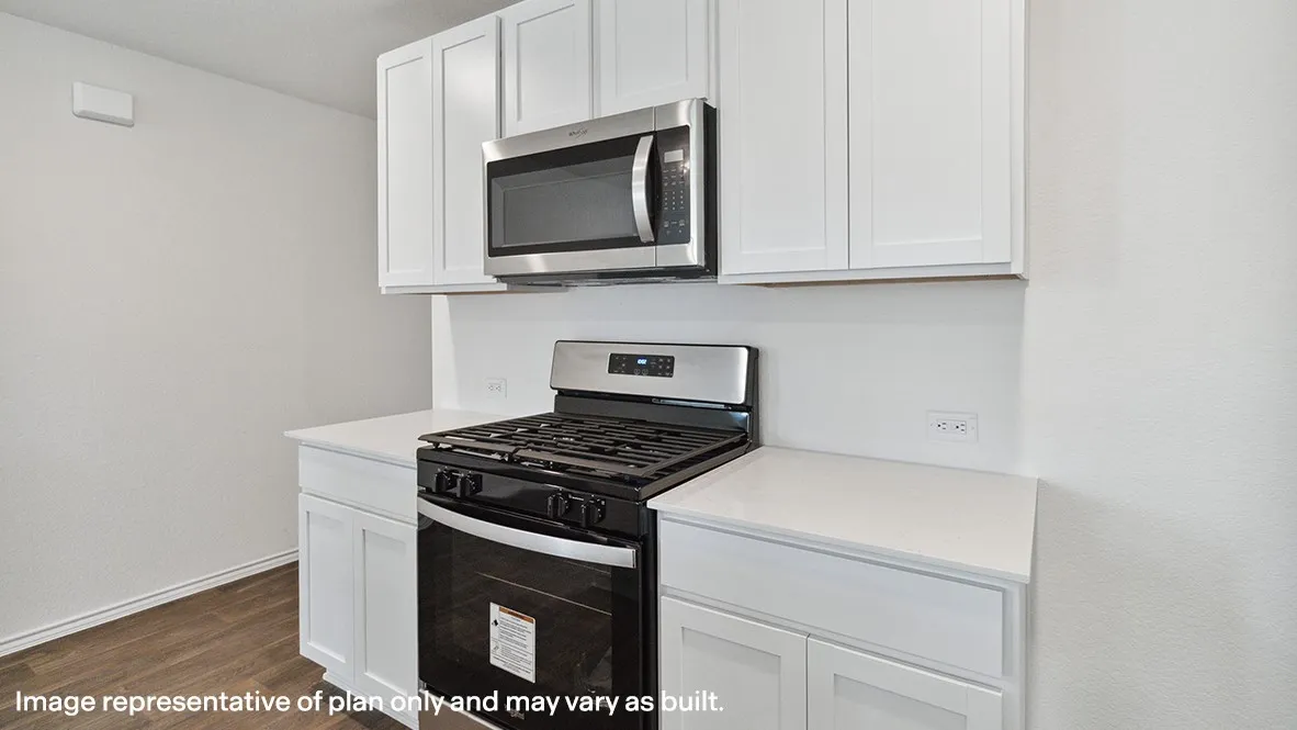 White shaker-style cabinetry, stainless steel microwave, stainless steel gas range, light-toned countertops, and wood-finish flooring