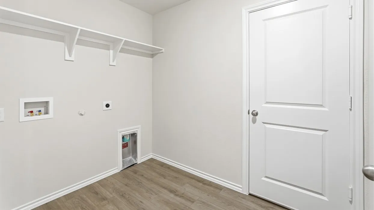 Laundry area featuring wood-finish flooring and built-in shelving