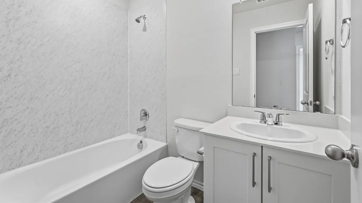 White vanity with a built-in sink, chrome fixtures, and a framed mirror