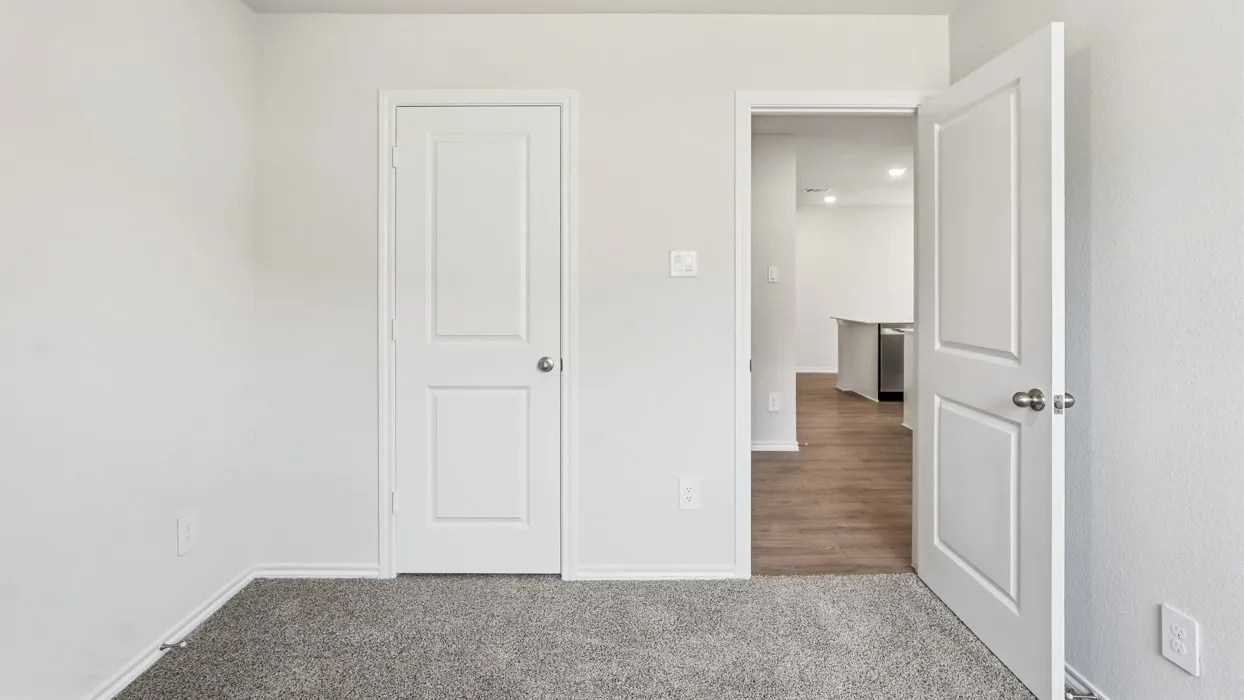 Textured carpeting and white interior doors with satin nickel hardware
