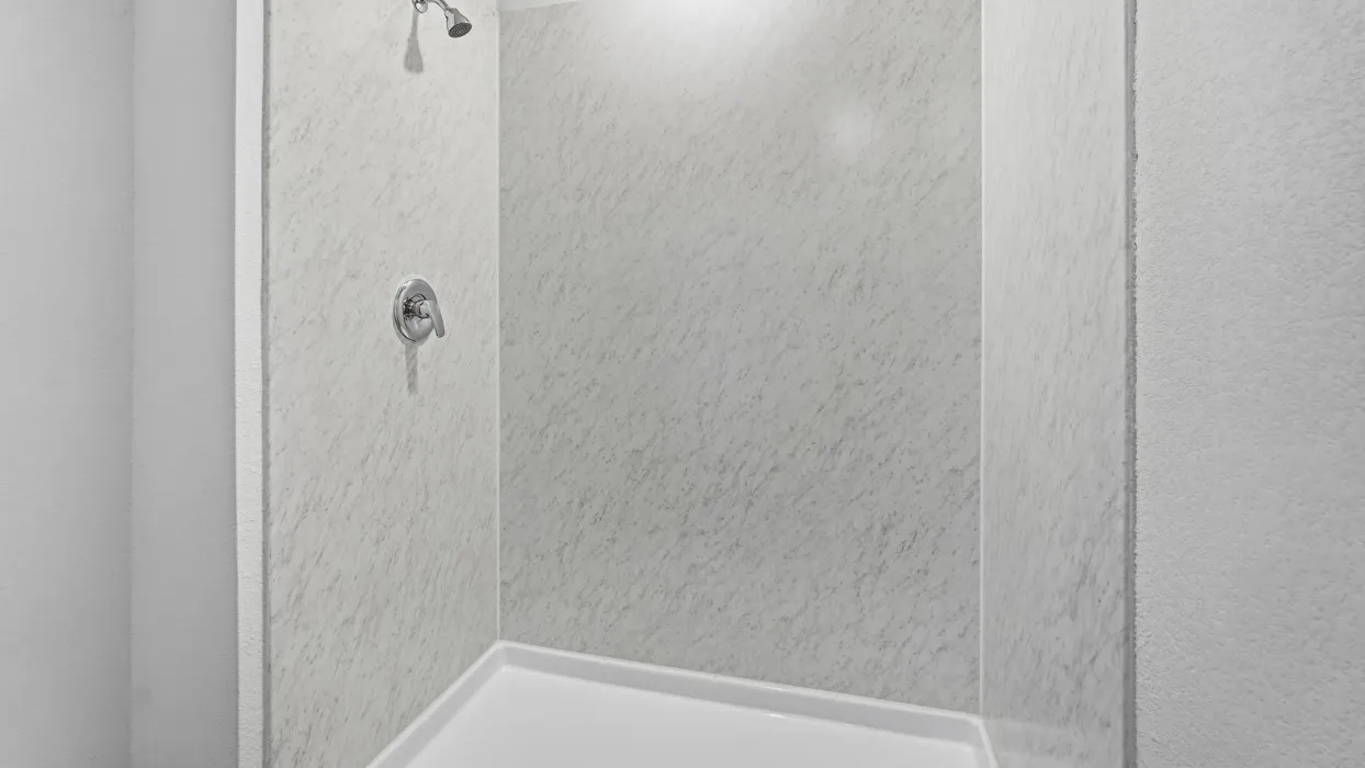 Enclosed shower with a white acrylic base and textured wall panels, featuring a chrome shower head and control handle