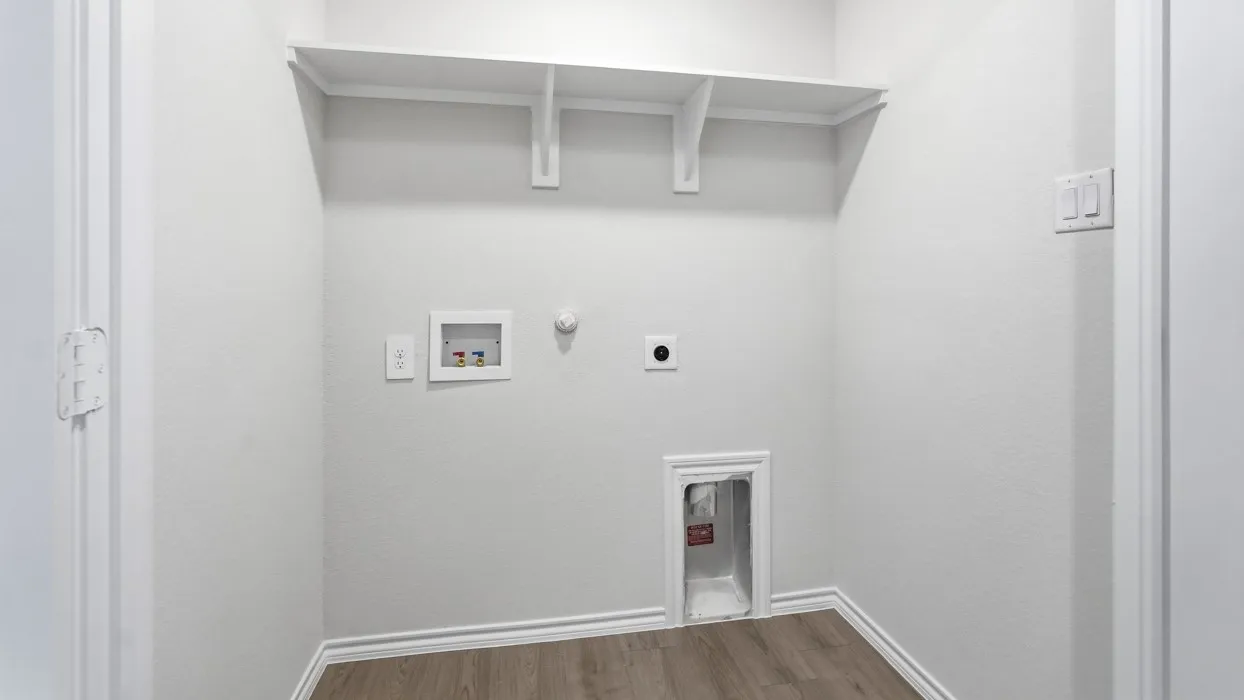 Utility space featuring wood-finish flooring, built-in shelving, and white baseboards