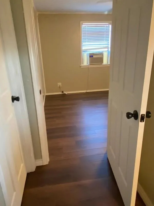 Dark wood-finish flooring with light-toned walls and white trim