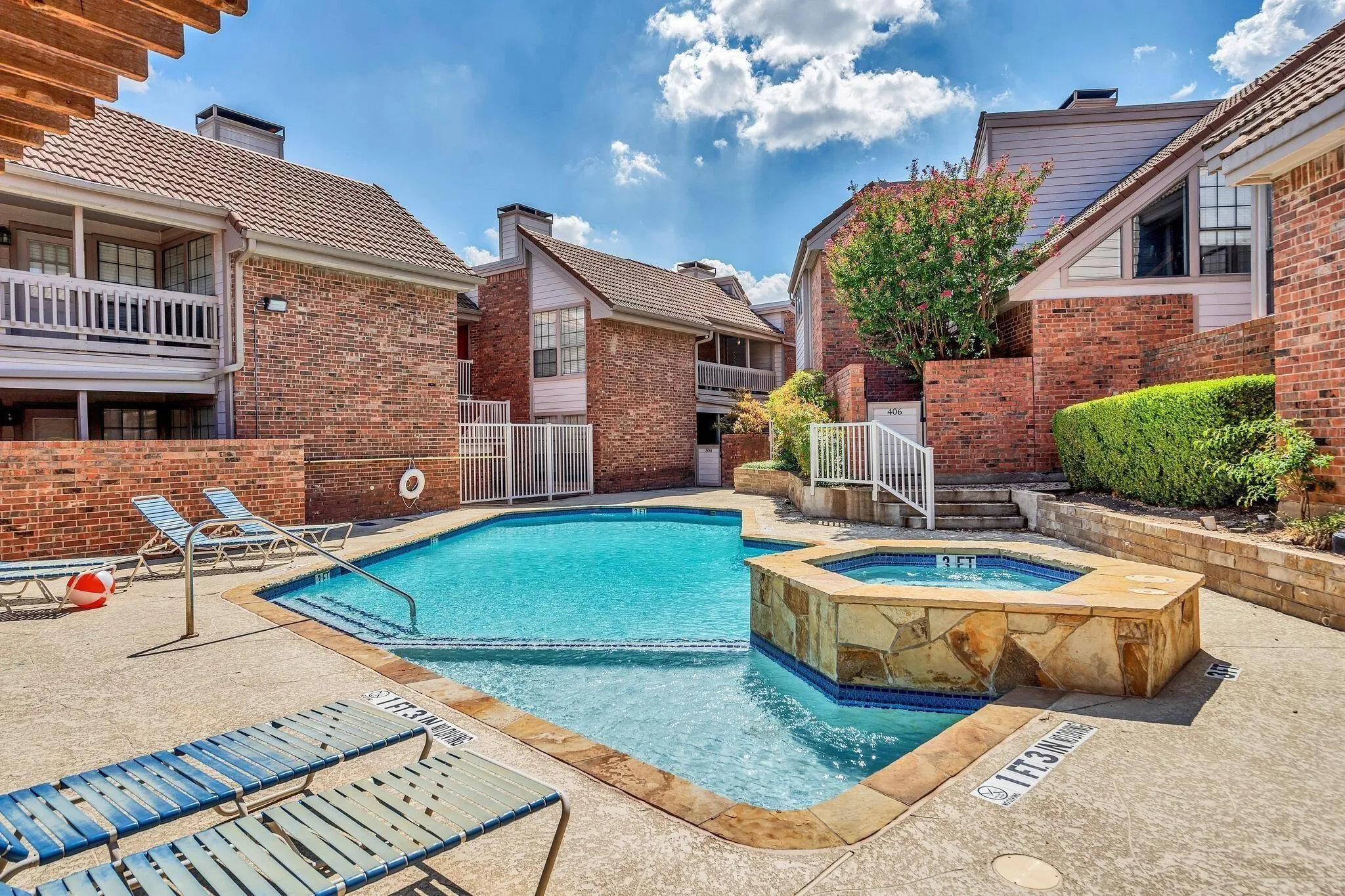 Community pool with integrated spa and surrounding concrete decking