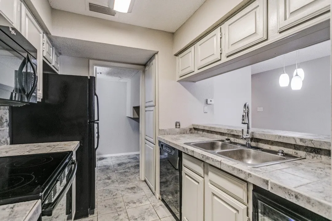 Kitchen featuring white cabinetry, stone-finish countertops, a double basin stainless steel sink, and tile flooring