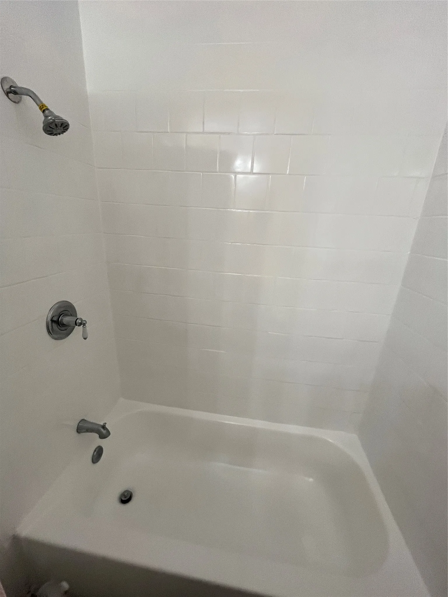 White subway tile surround with chrome fixtures and a white tub